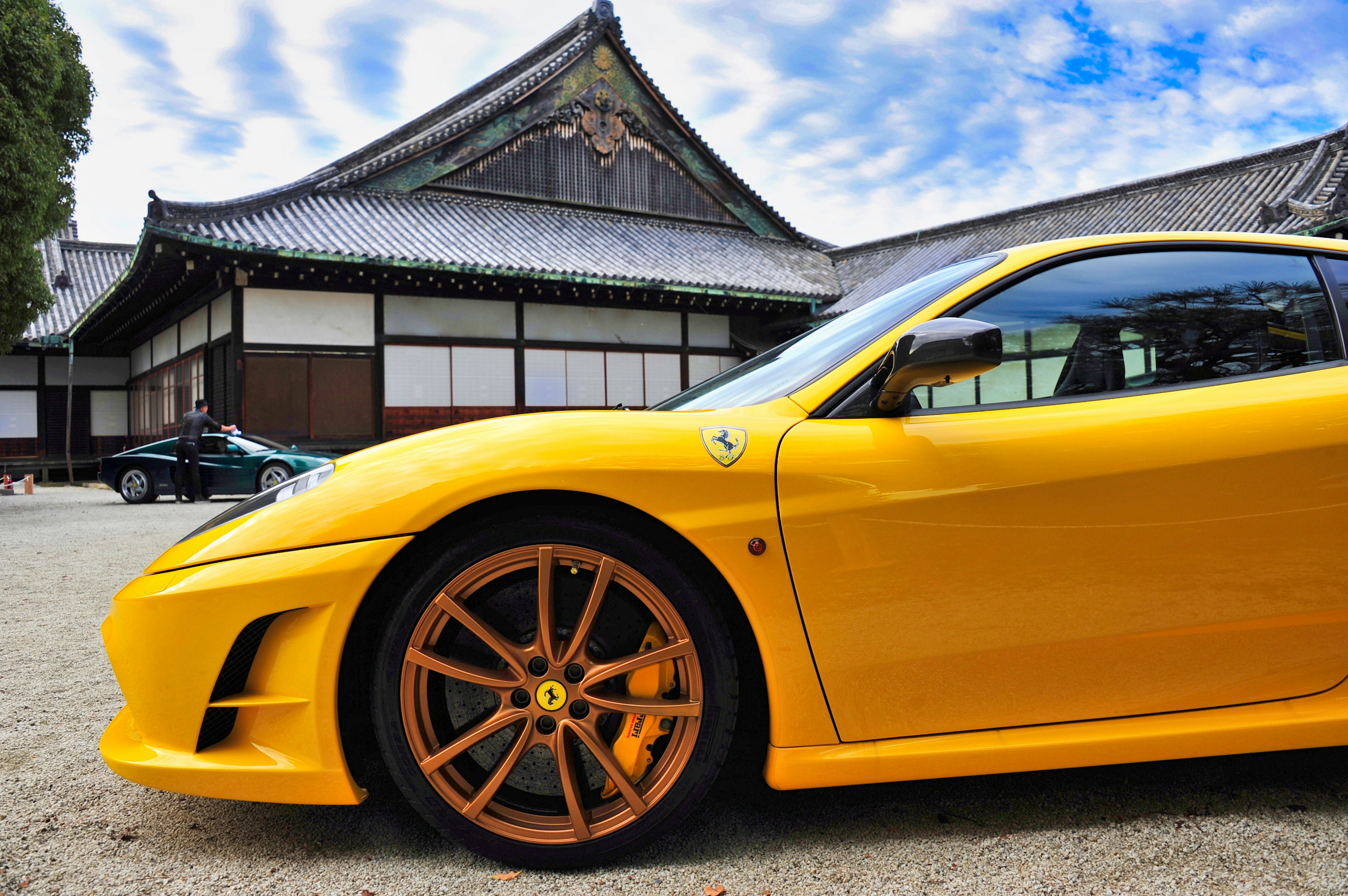 Yellow sports car with traditional Japanese architecture in background