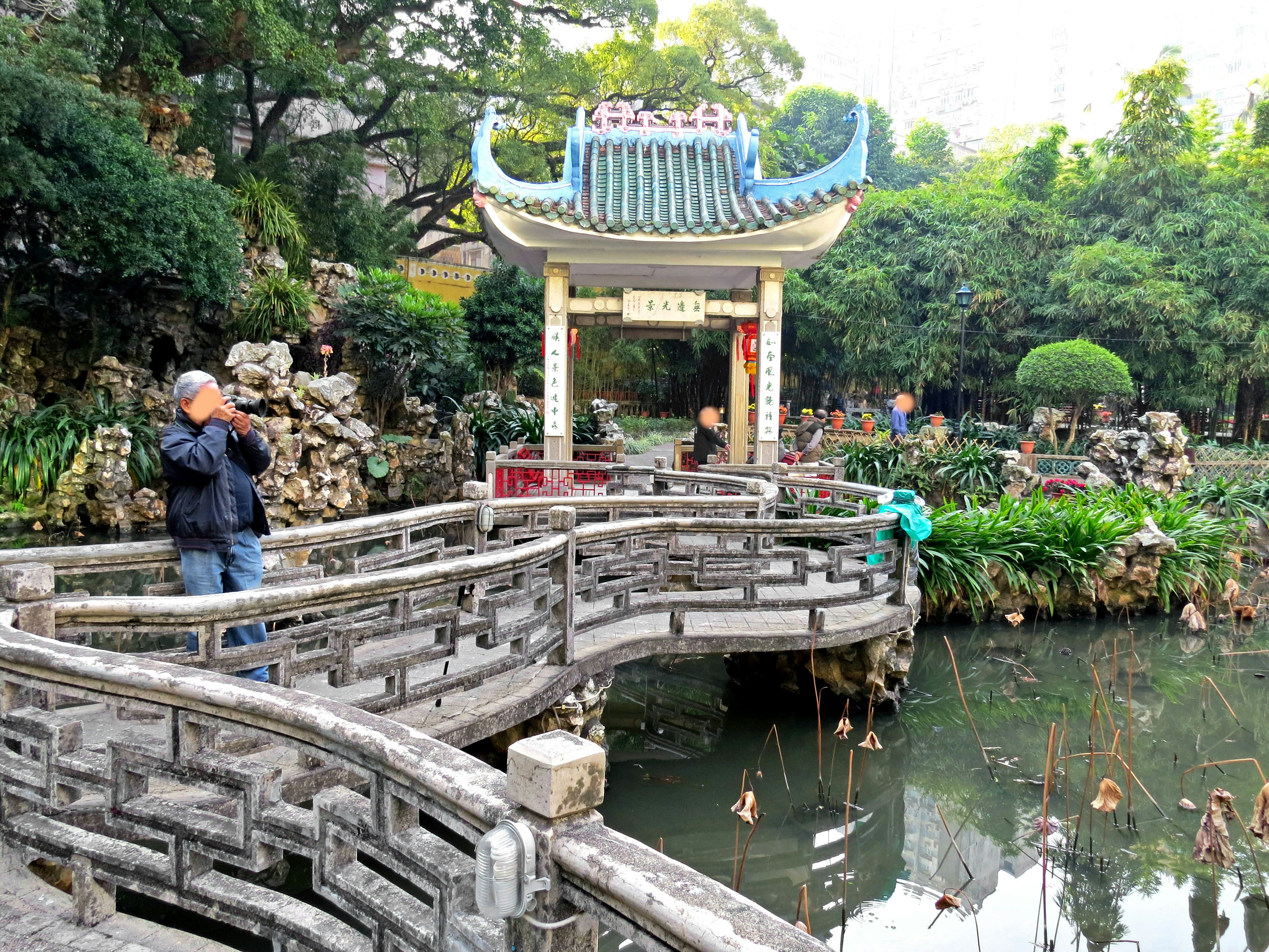 Scenic view of a bridge in a garden with a traditional Chinese pavilion