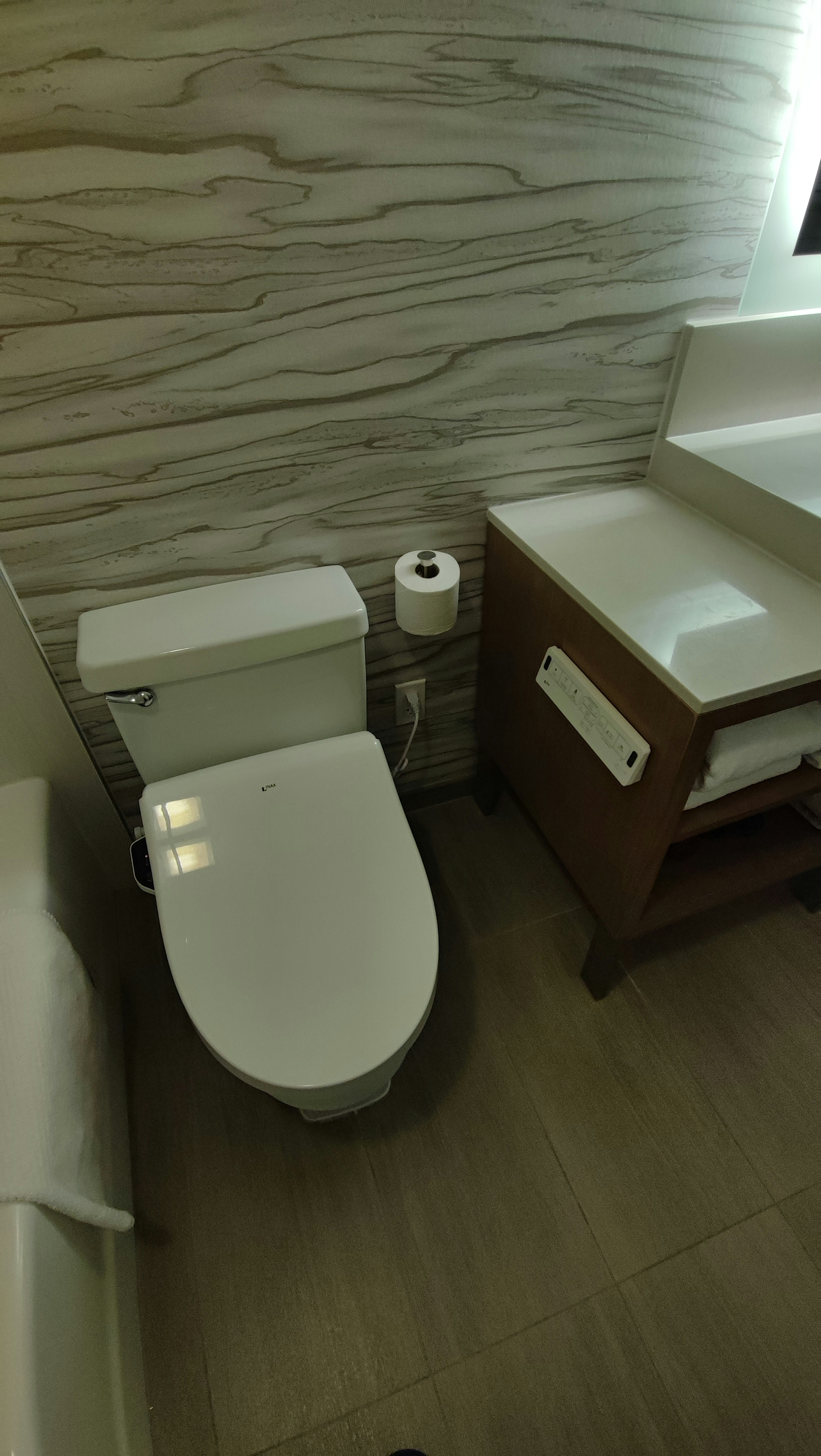 Top view of a modern toilet and wooden storage in a bathroom