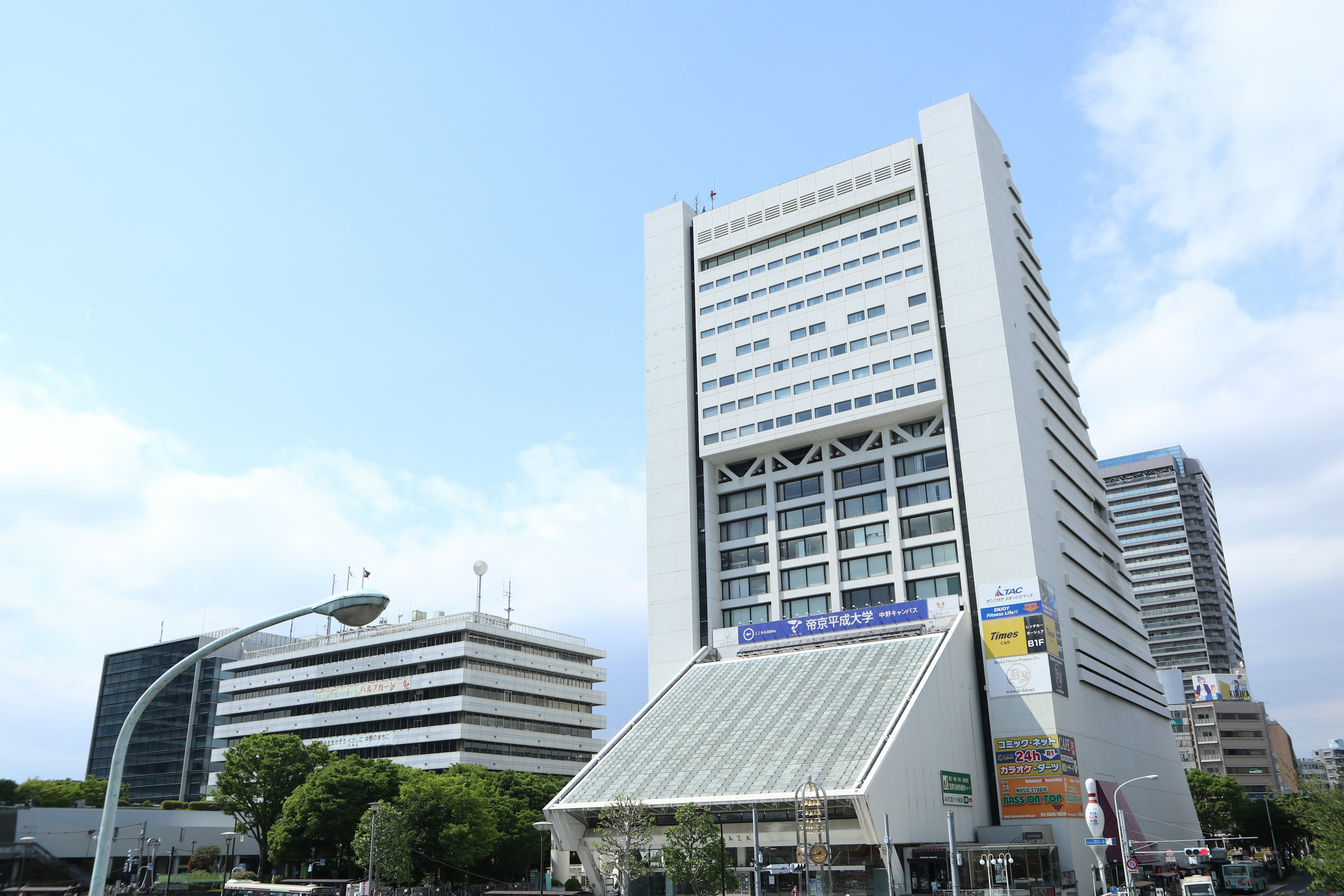 Gedung kantor modern dengan fasad putih di bawah langit biru