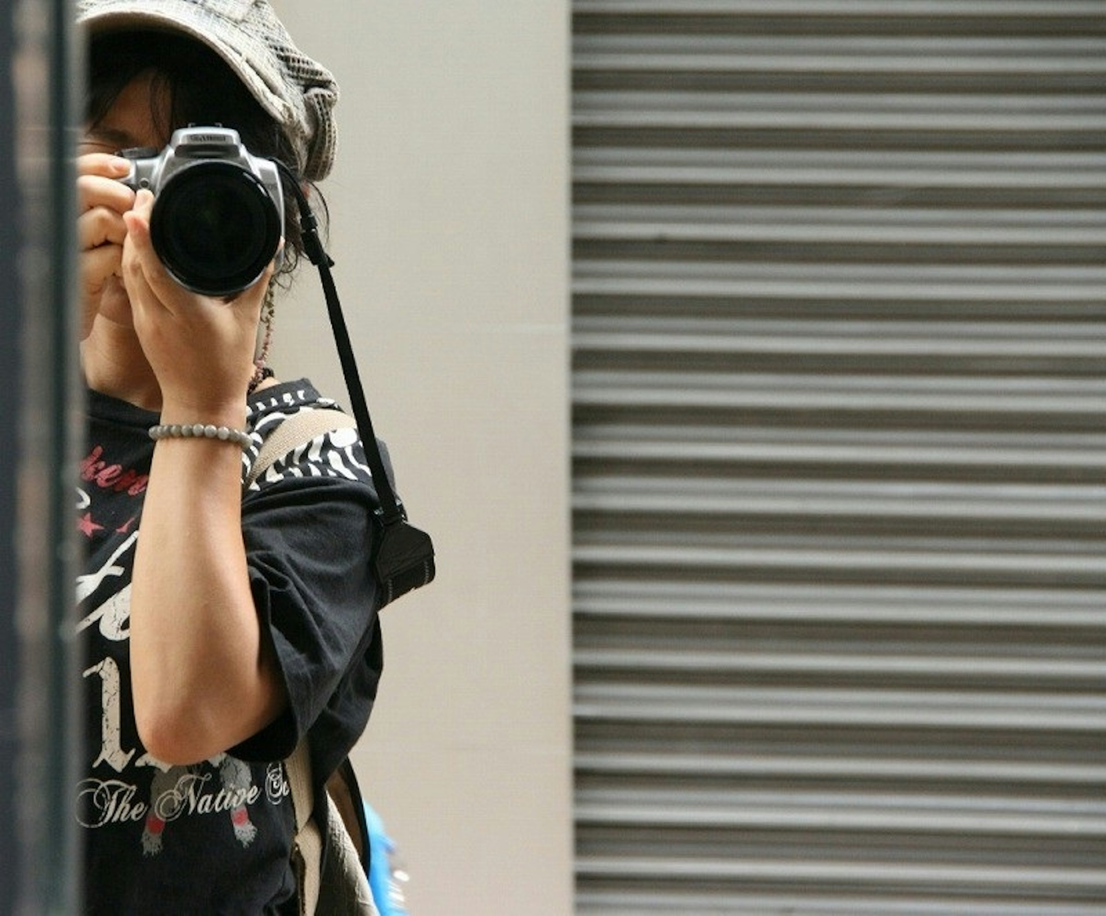 Young woman taking a selfie with a camera in front of a mirror