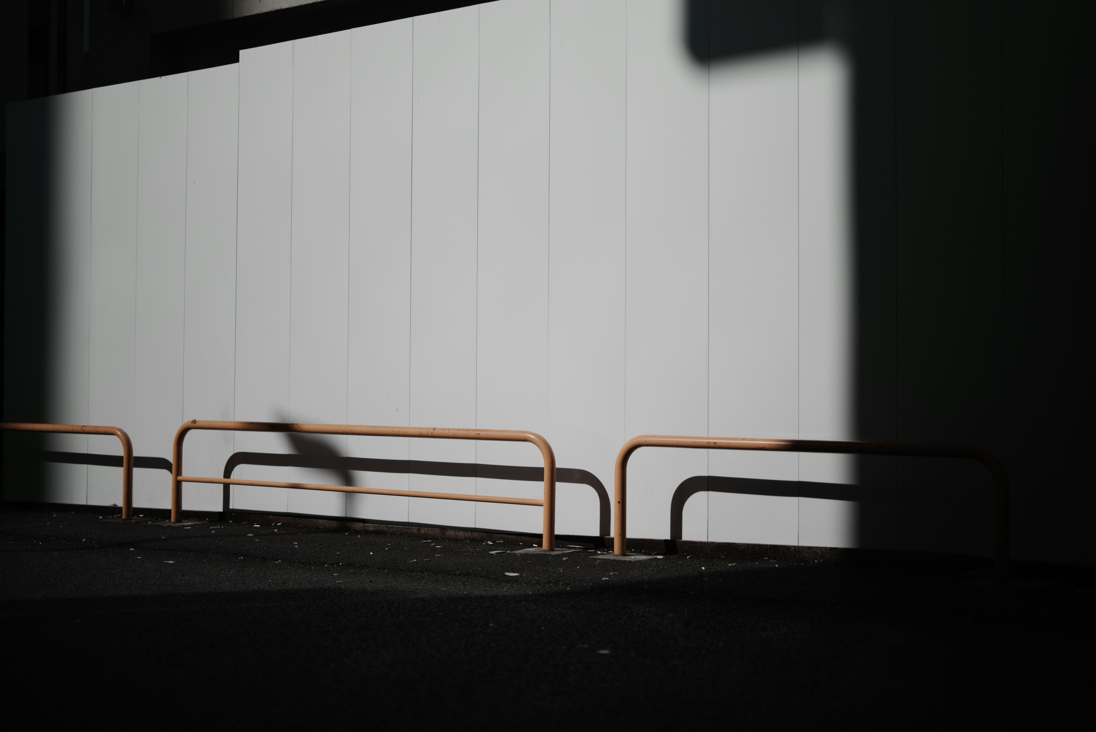 Scène urbaine avec un mur blanc et des ombres contrastées