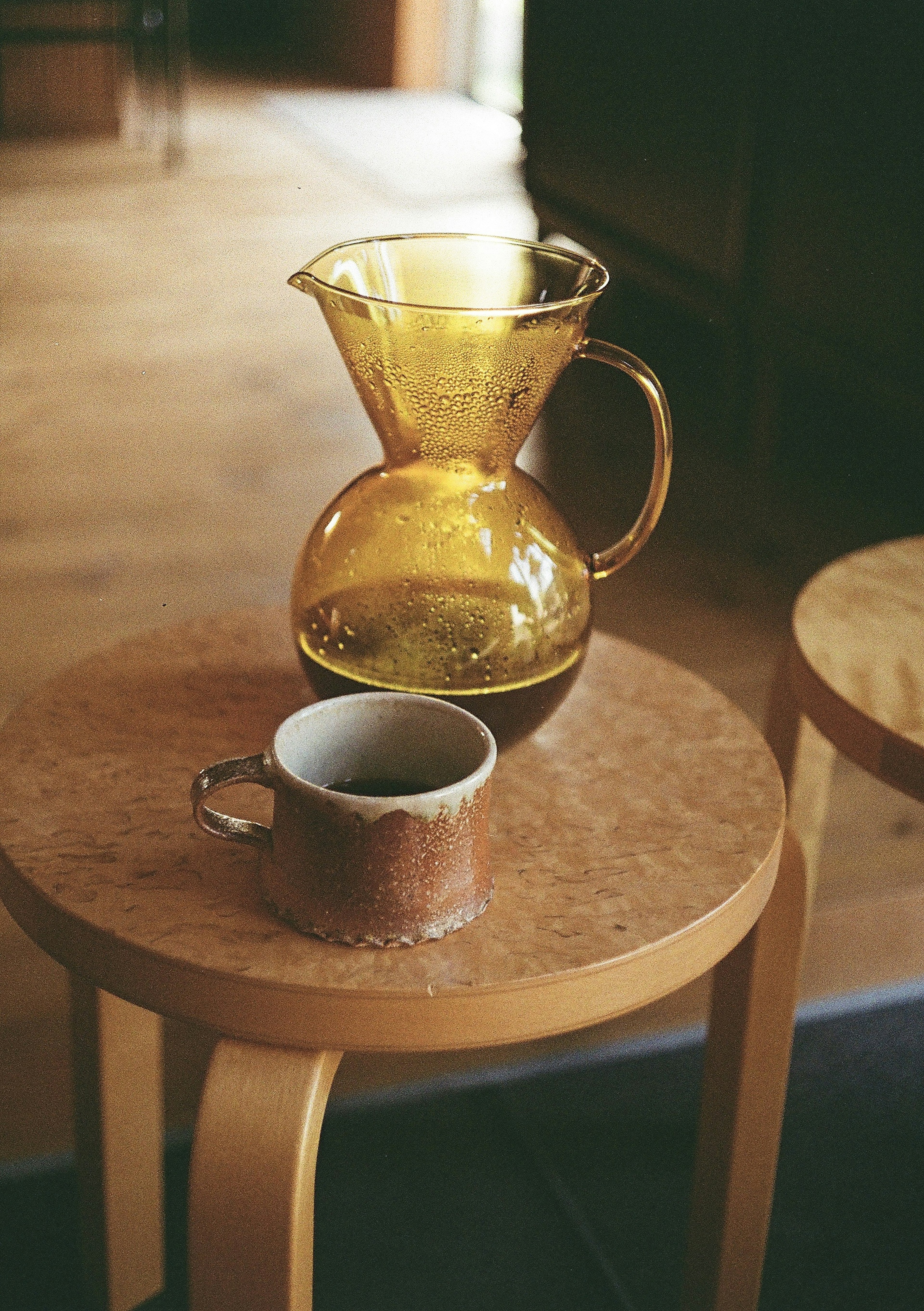 A coffee pot and cup on a wooden table