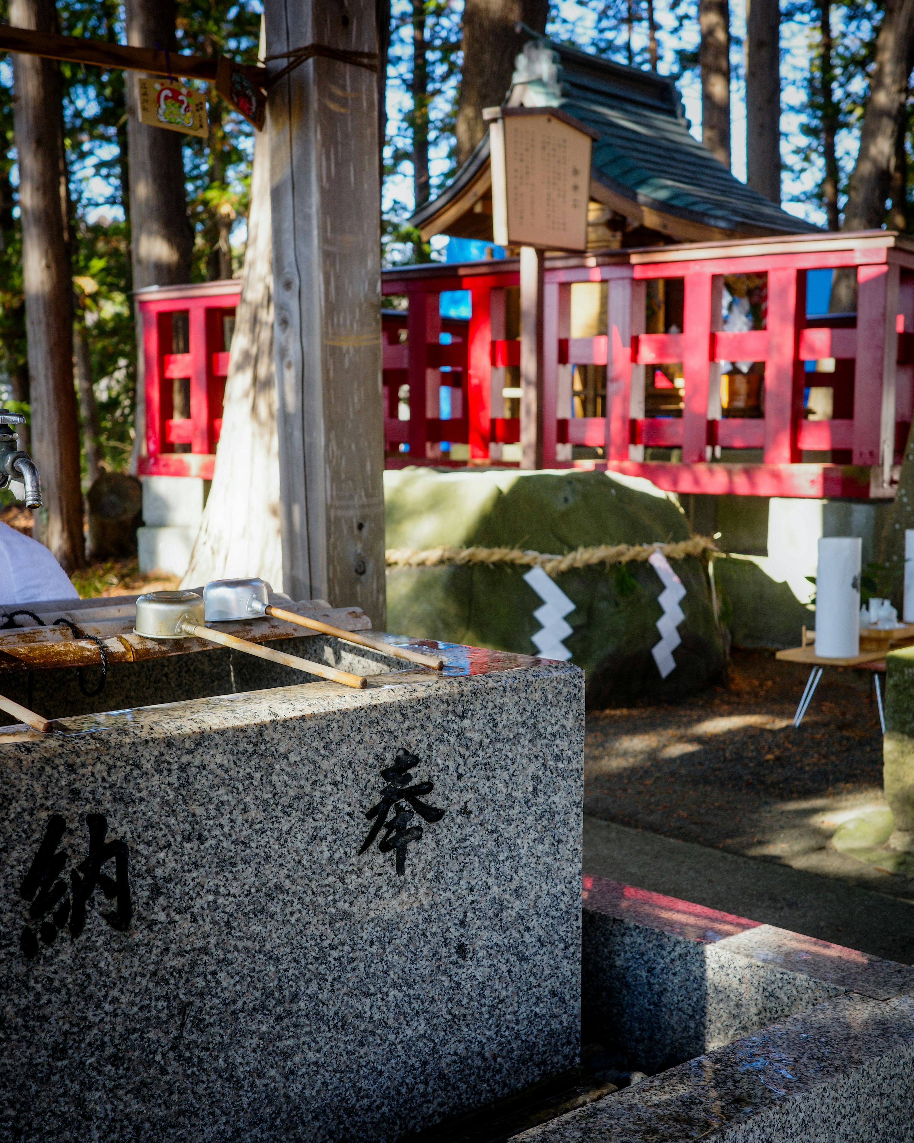 神社の境内にある石の祭壇と赤い木の囲い