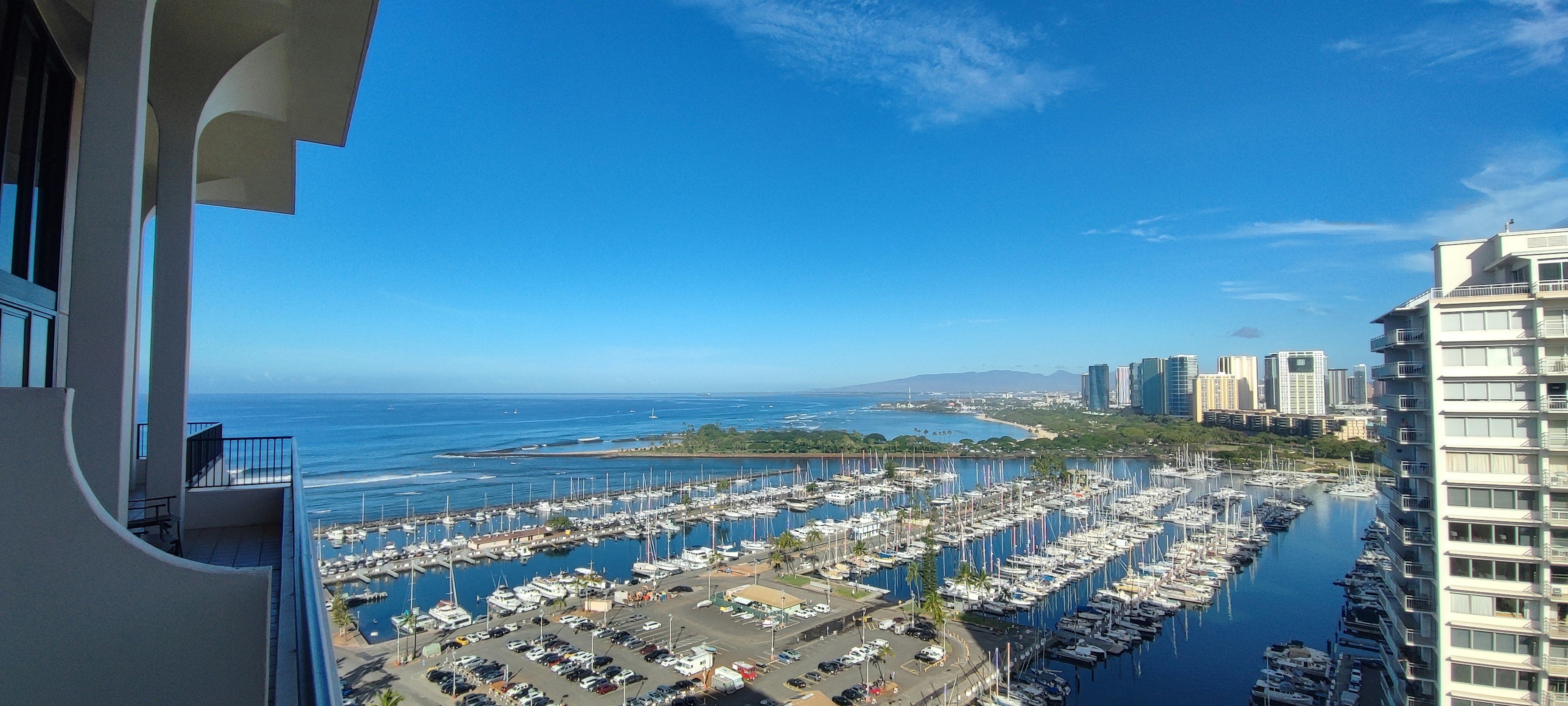 Panoramic view of marina with blue sky and ocean from high-rise building window