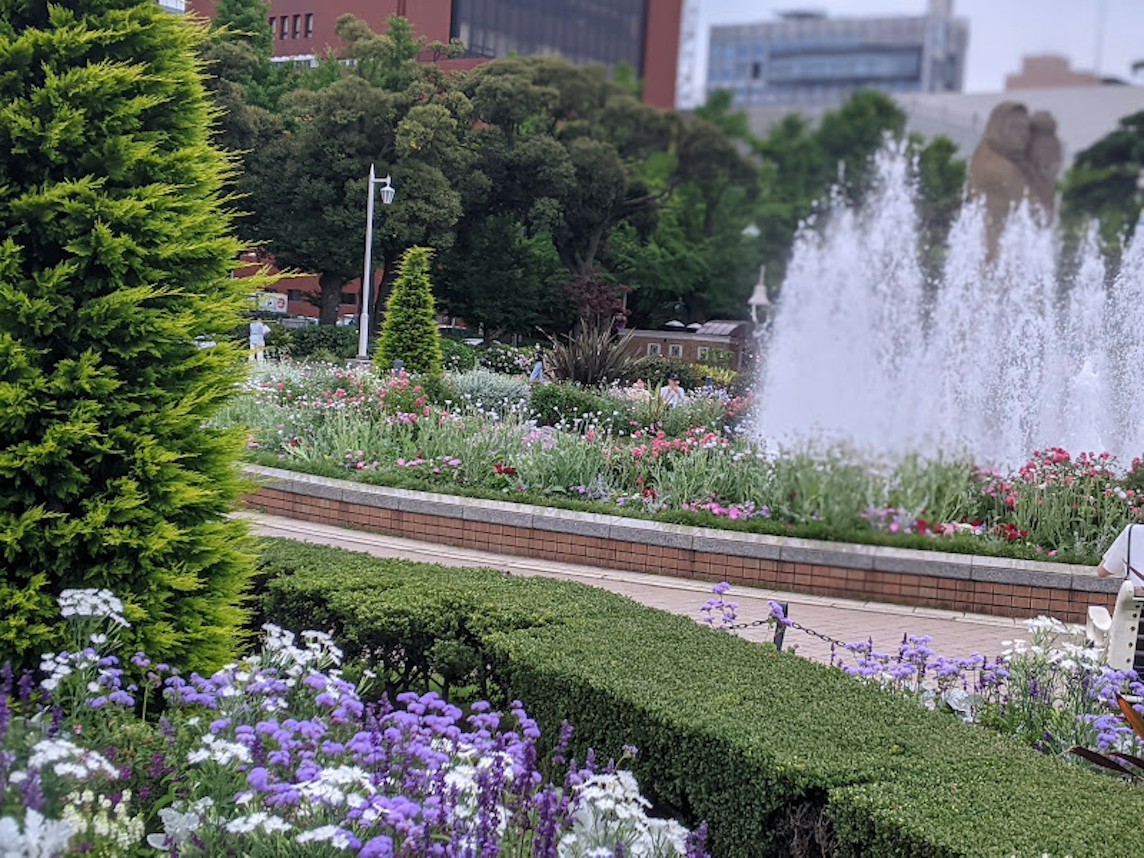 Paisaje de parque exuberante con parterres de flores y una fuente