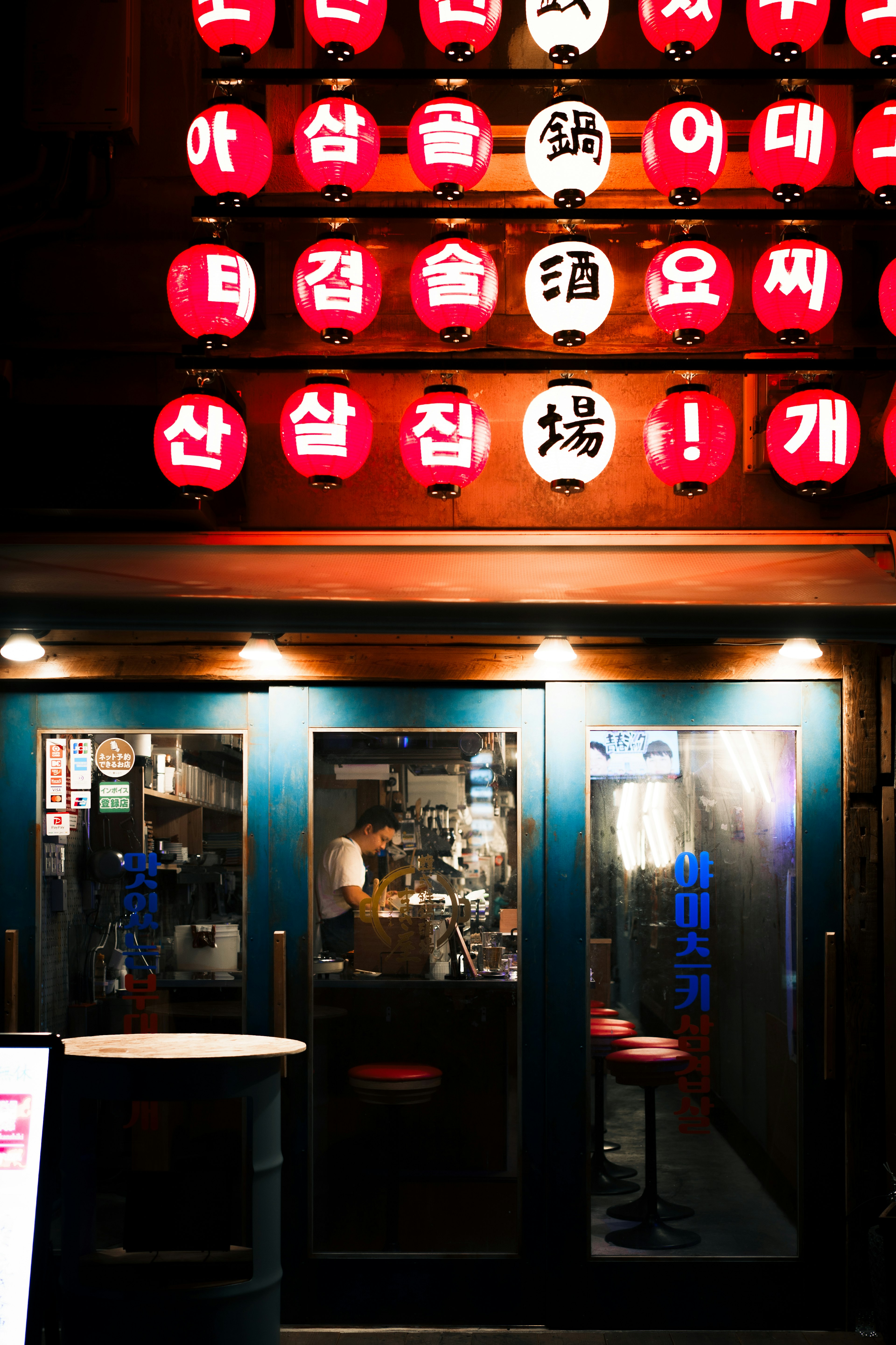 Eingang eines koreanischen Izakaya geschmückt mit leuchtend roten Laternen Warmes und einladendes Licht