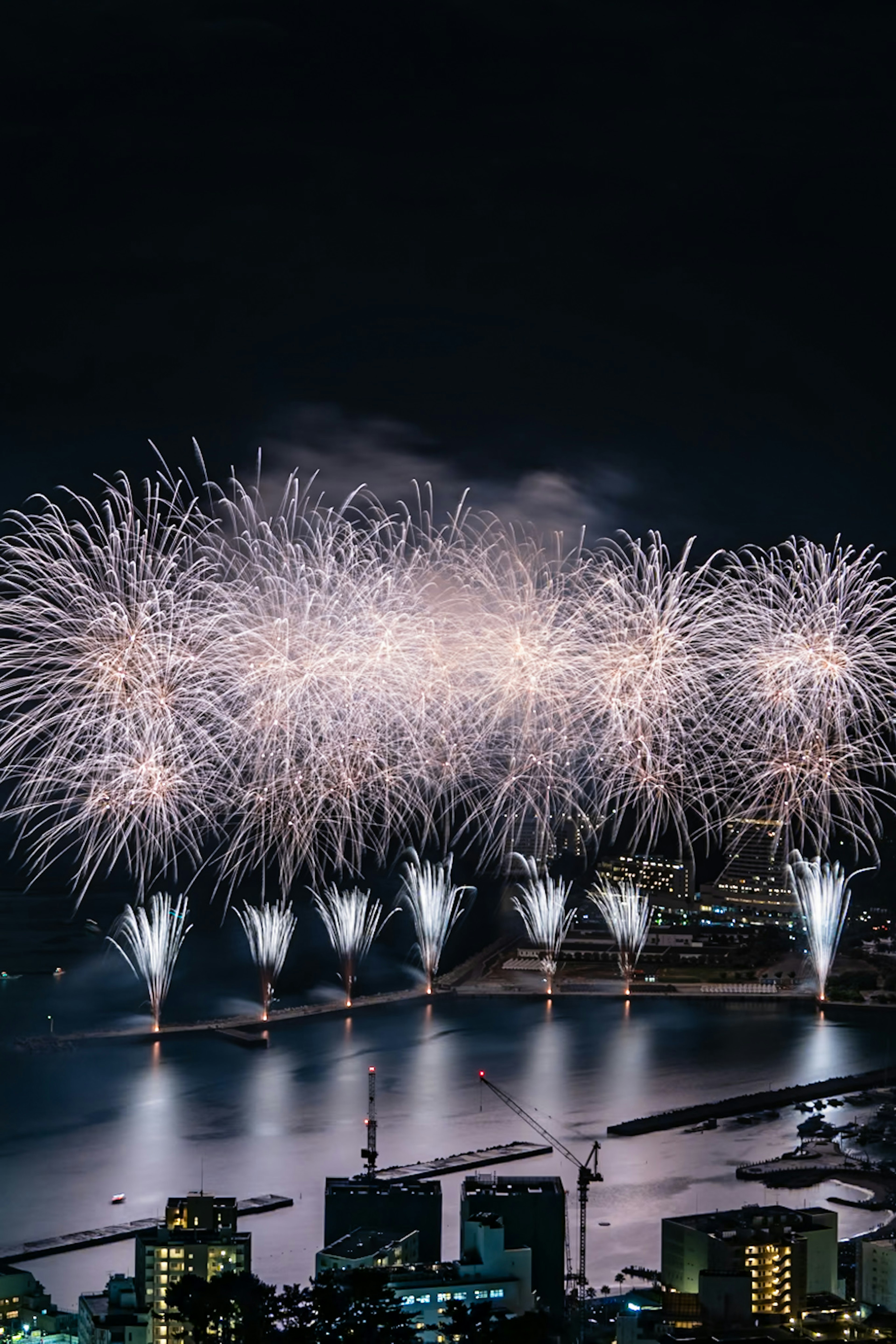 Beautiful fireworks display reflected on water at night