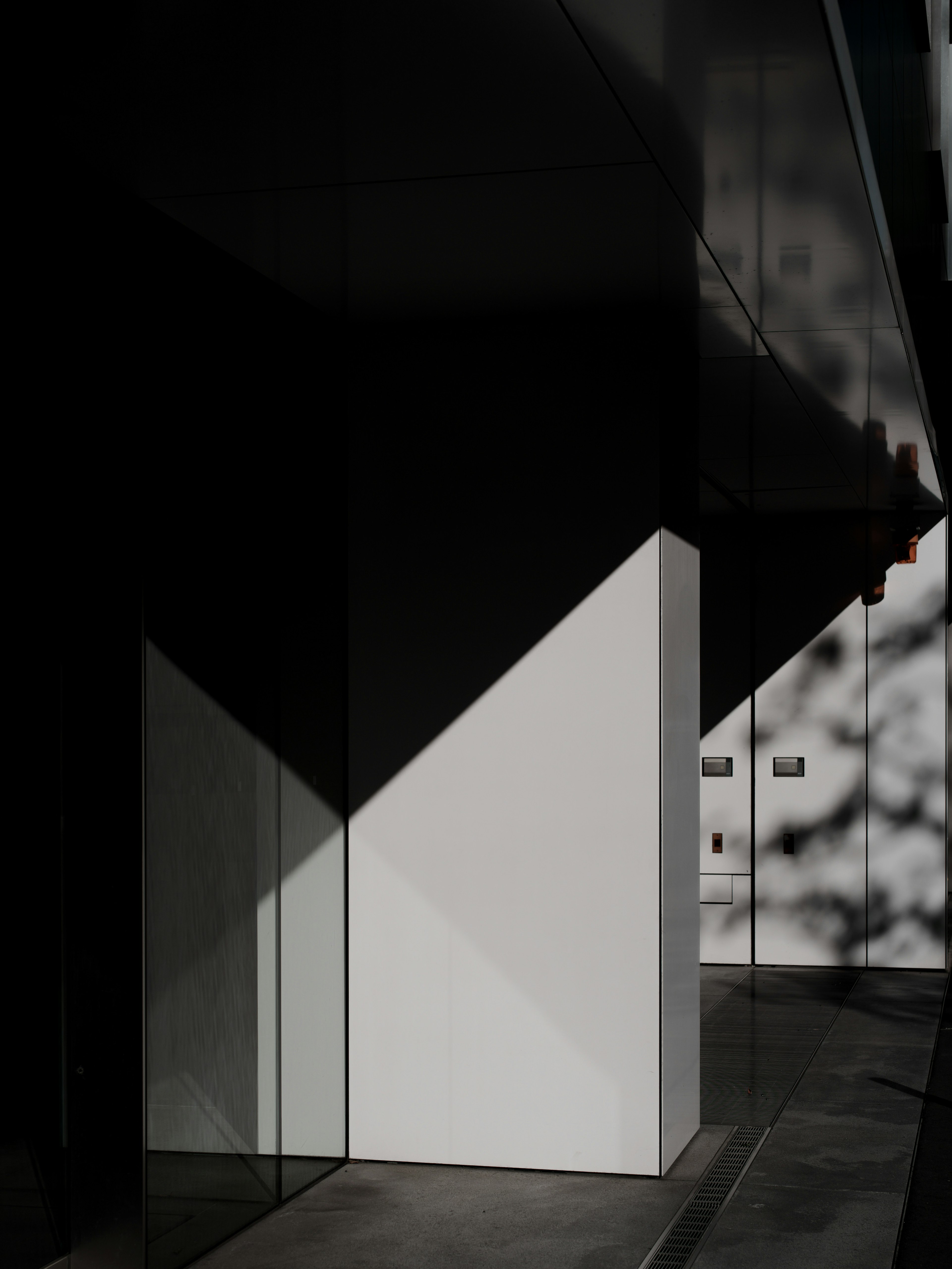 Modern architectural detail featuring a white wall and striking shadows