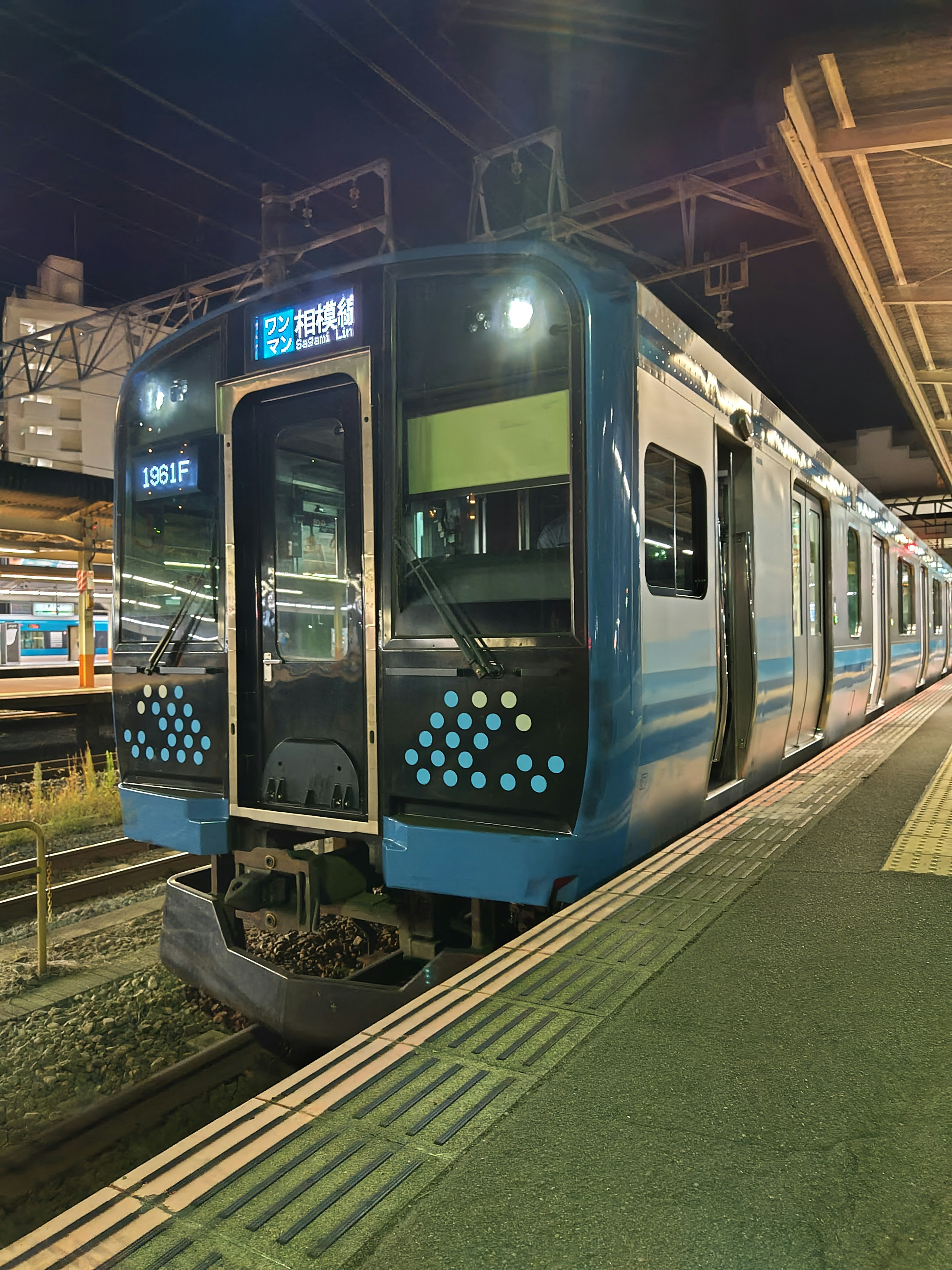 Tren azul detenido en una estación de noche