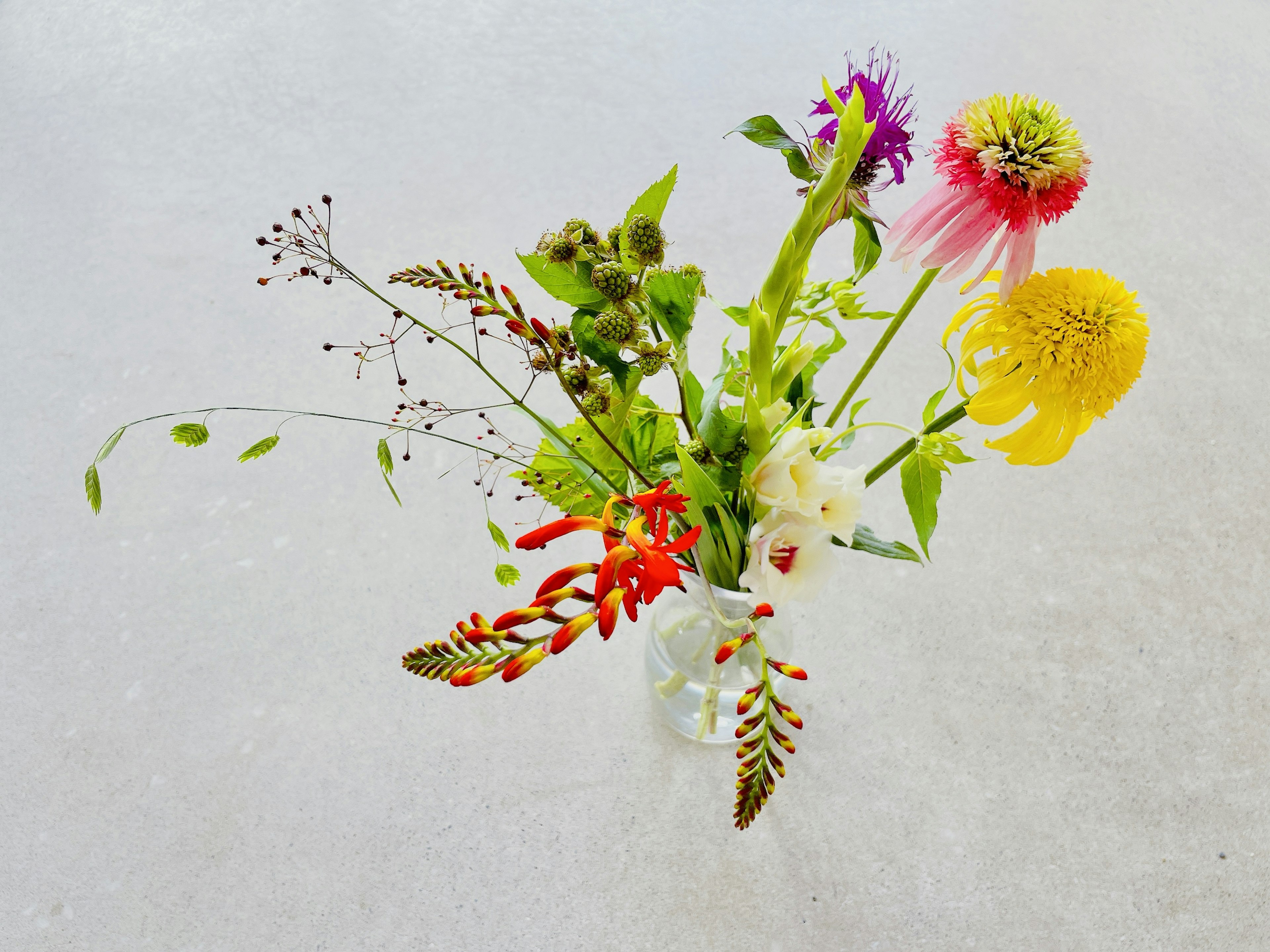 Ein Strauß mit einer Vielzahl von bunten Blumen und grünem Laub