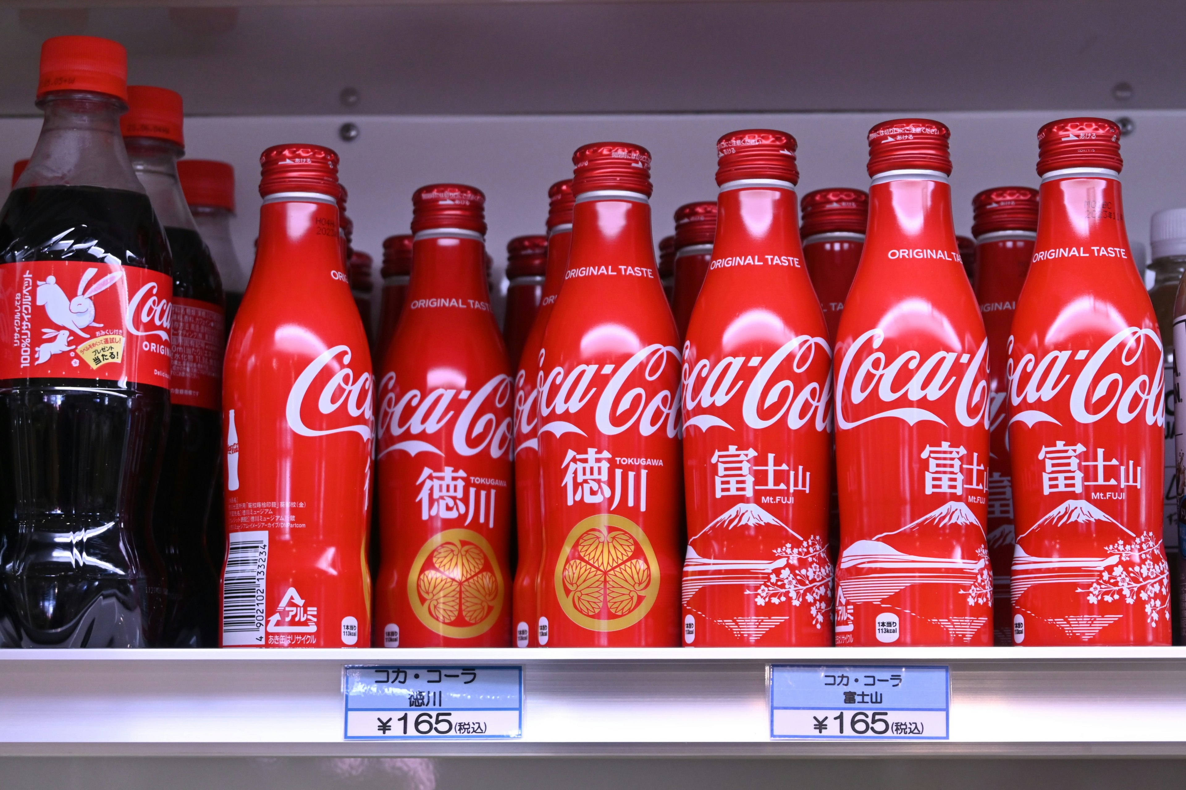 Hình ảnh các chai Coca-Cola đỏ được sắp xếp trên kệ