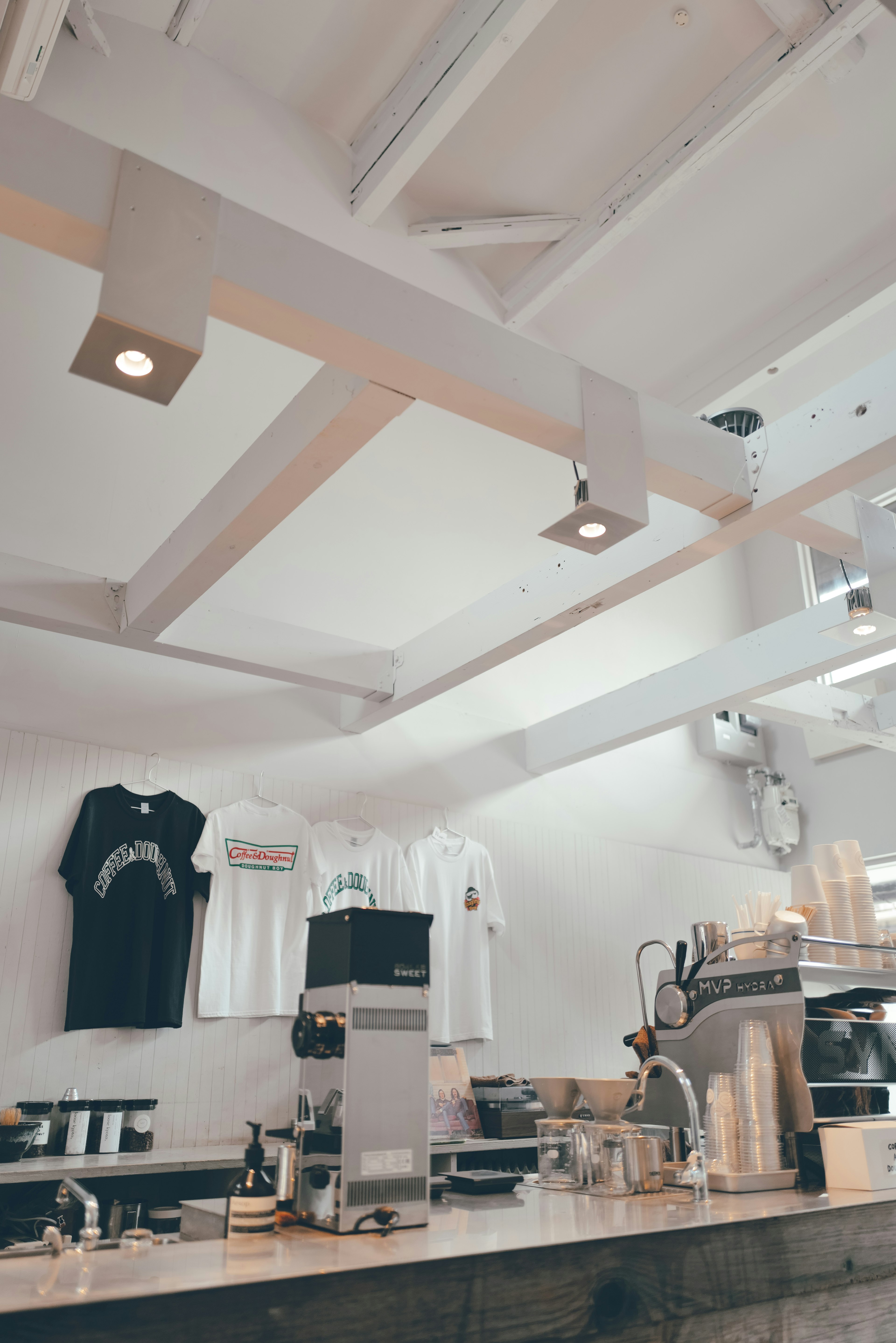 Bright interior of a cafe featuring a white ceiling and lighting fixtures