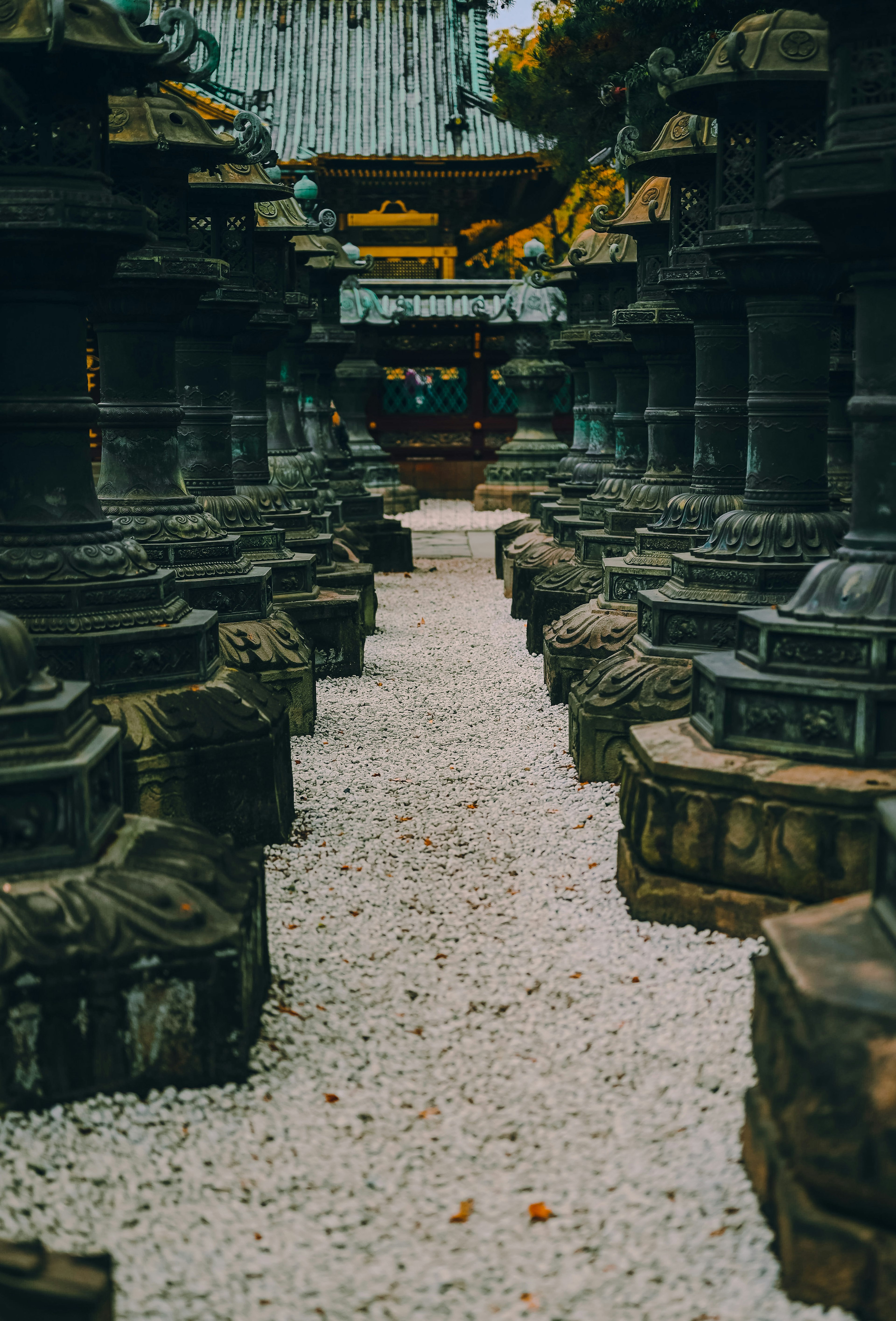 Stone towers lined along a gravel path in a temple courtyard