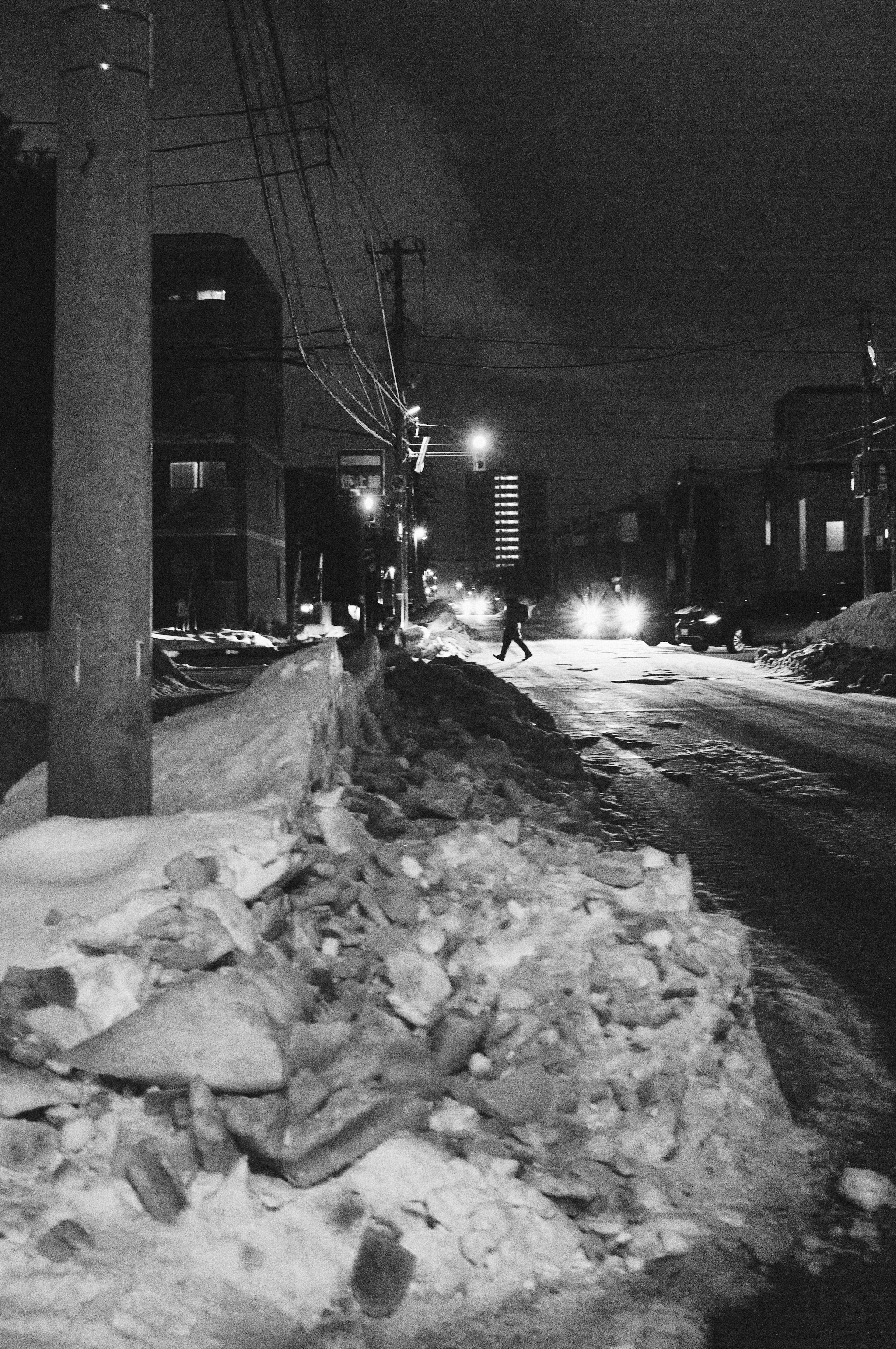 Neve accumulata sulla strada di notte con pali della luce