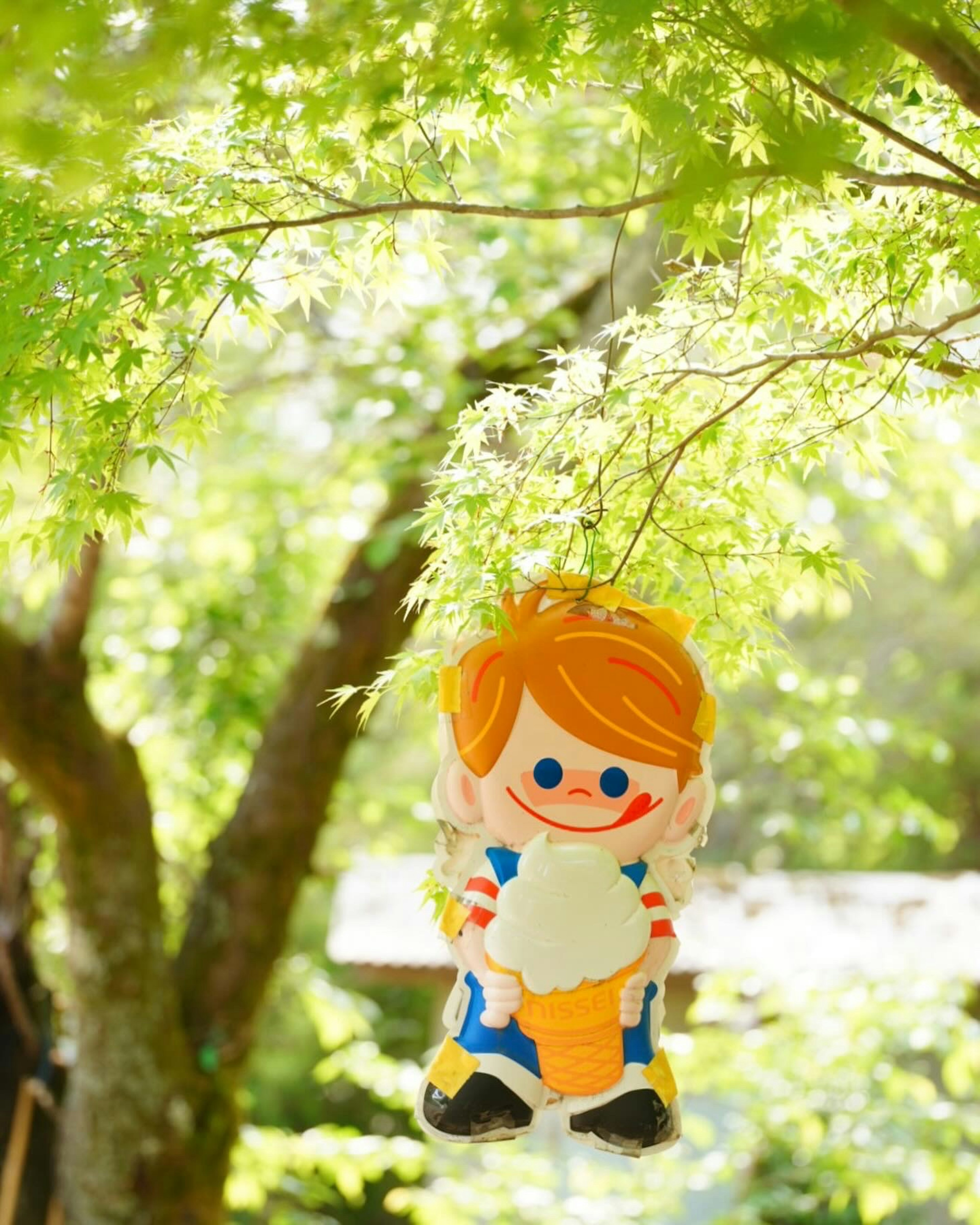 Child character holding ice cream hanging between green trees