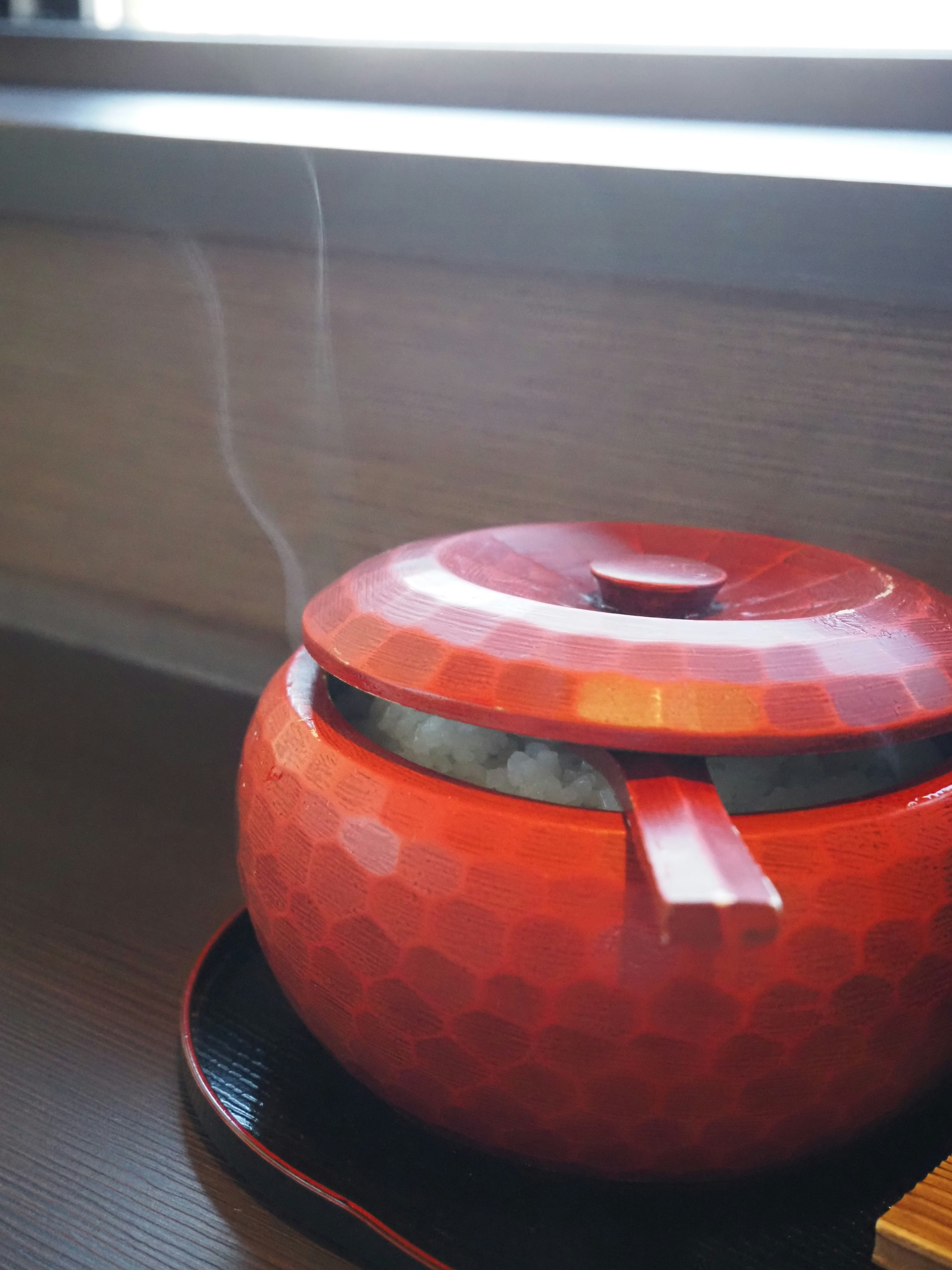 Tetera hexagonal roja con vapor que se eleva