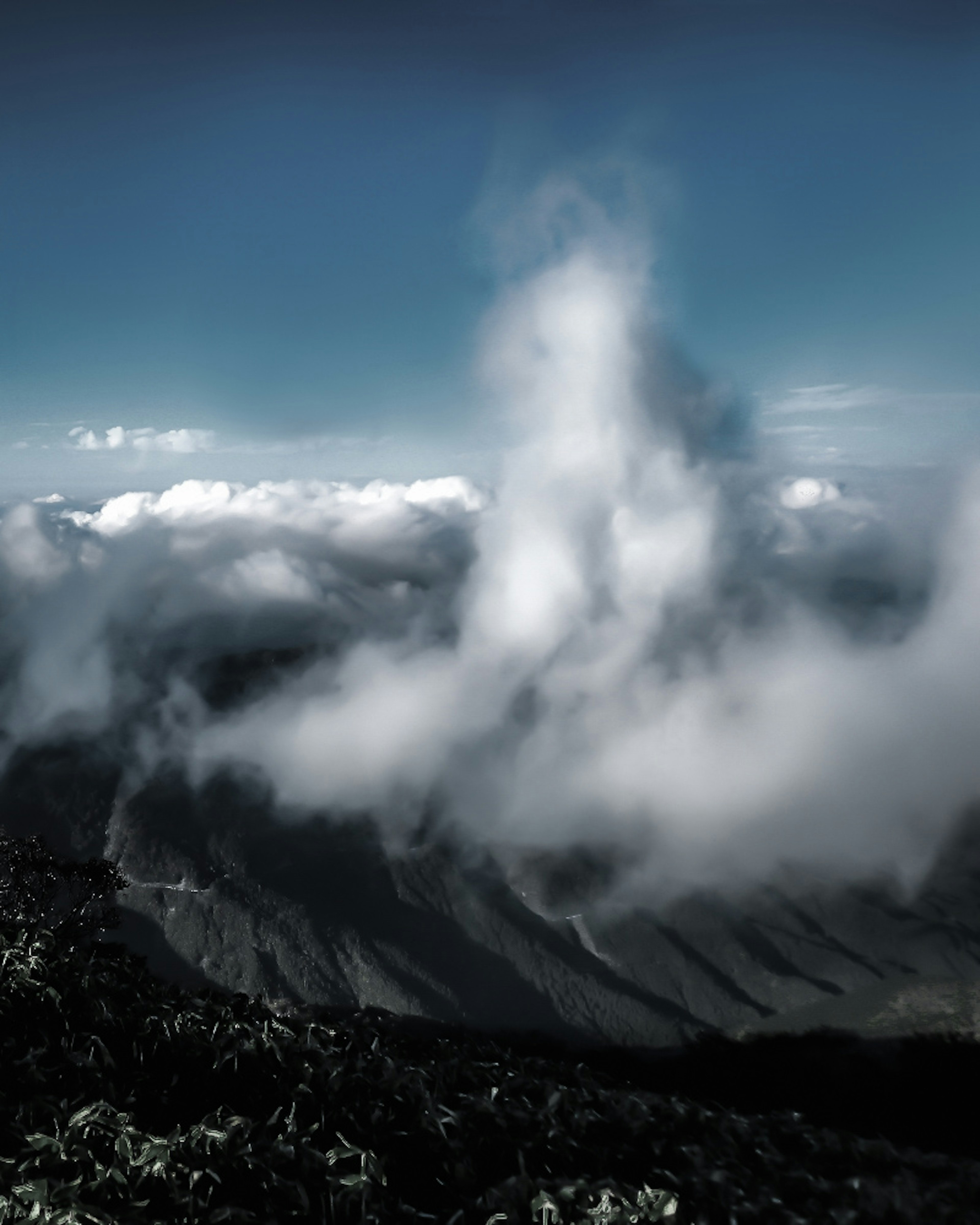 Foto lanskap dengan awan melayang di antara gunung