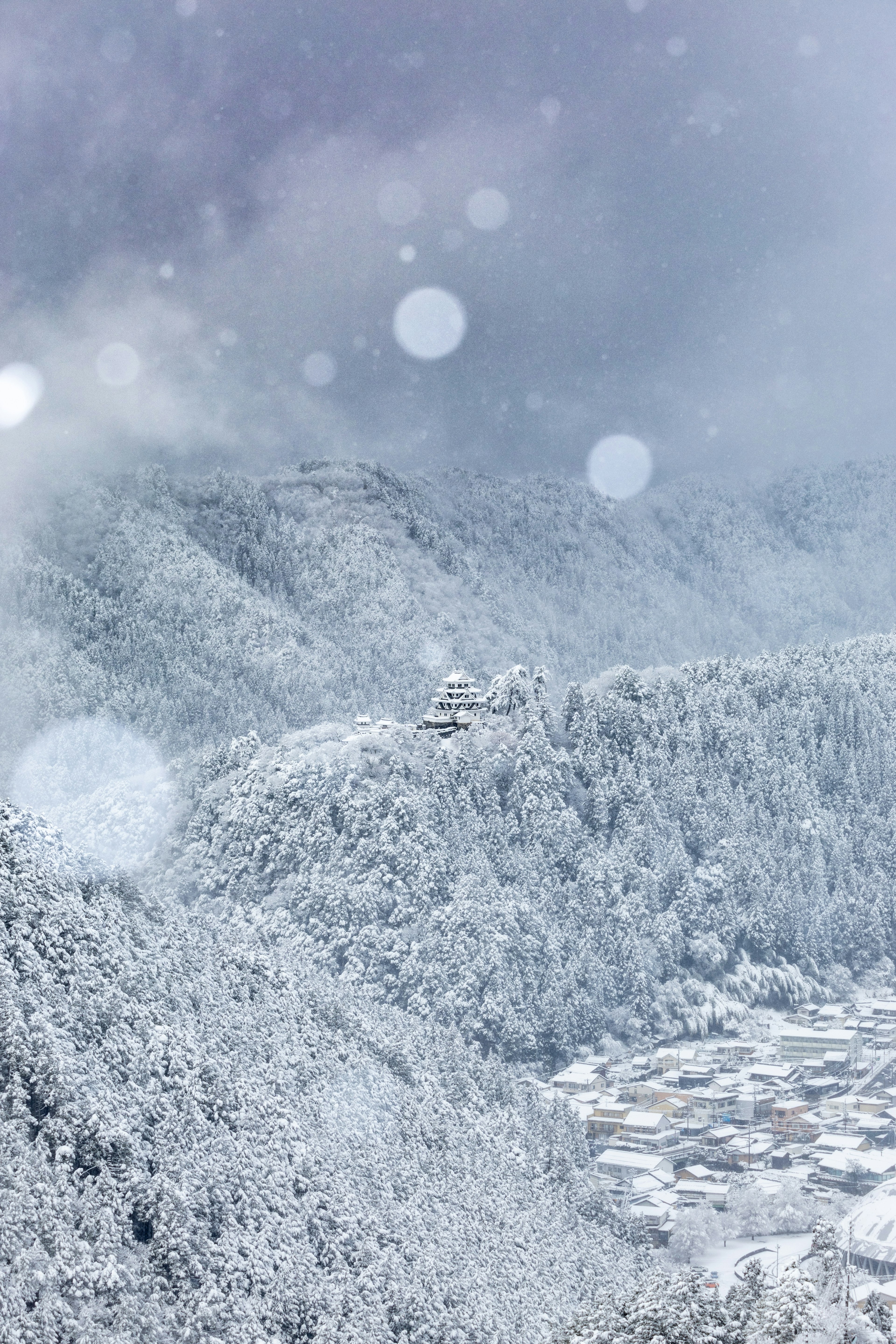 Paesaggio di montagne innevate e villaggio sotto un cielo nuvoloso