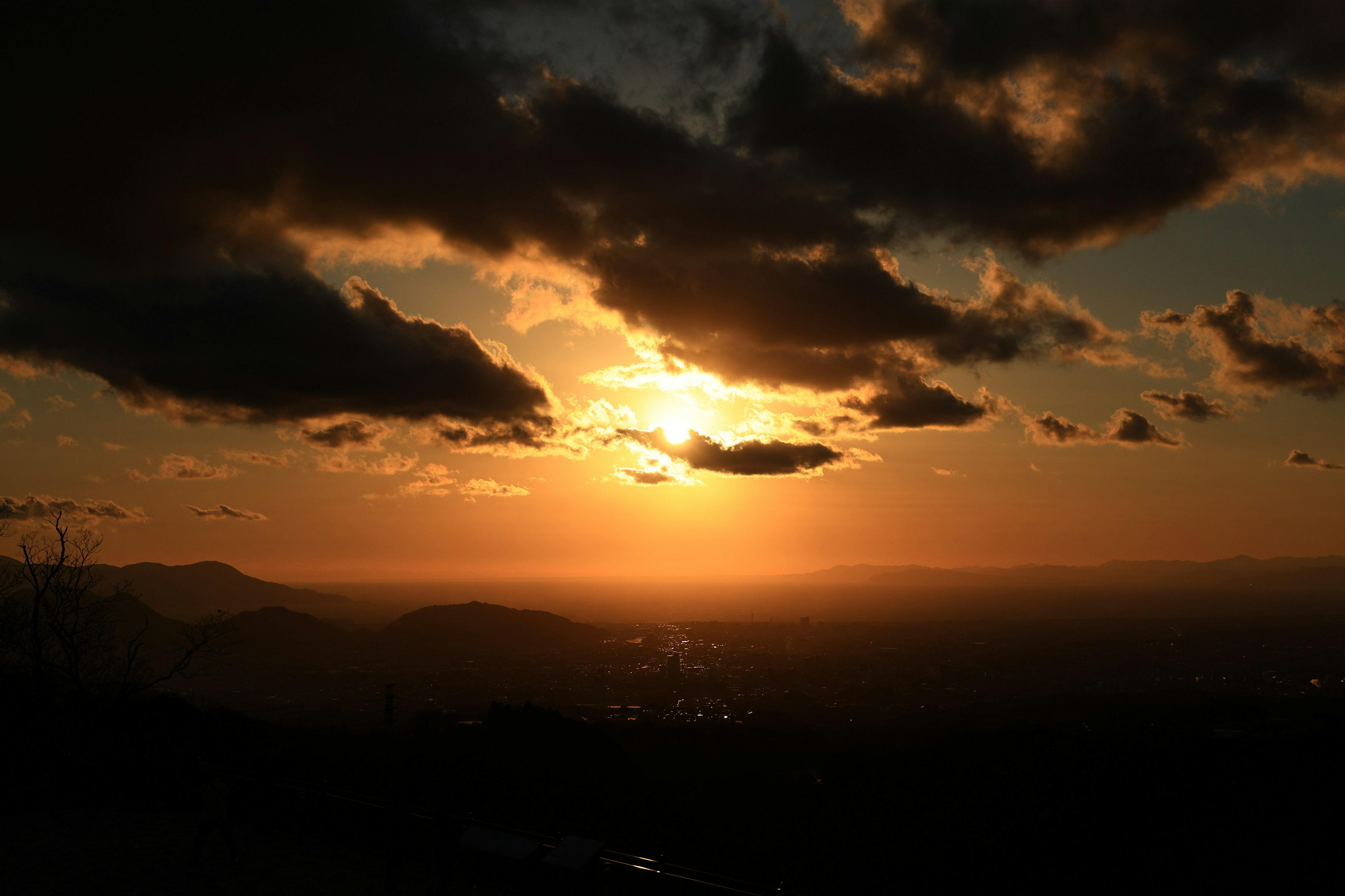 Paesaggio bellissimo con un tramonto, nuvole sparse, montagne sullo sfondo