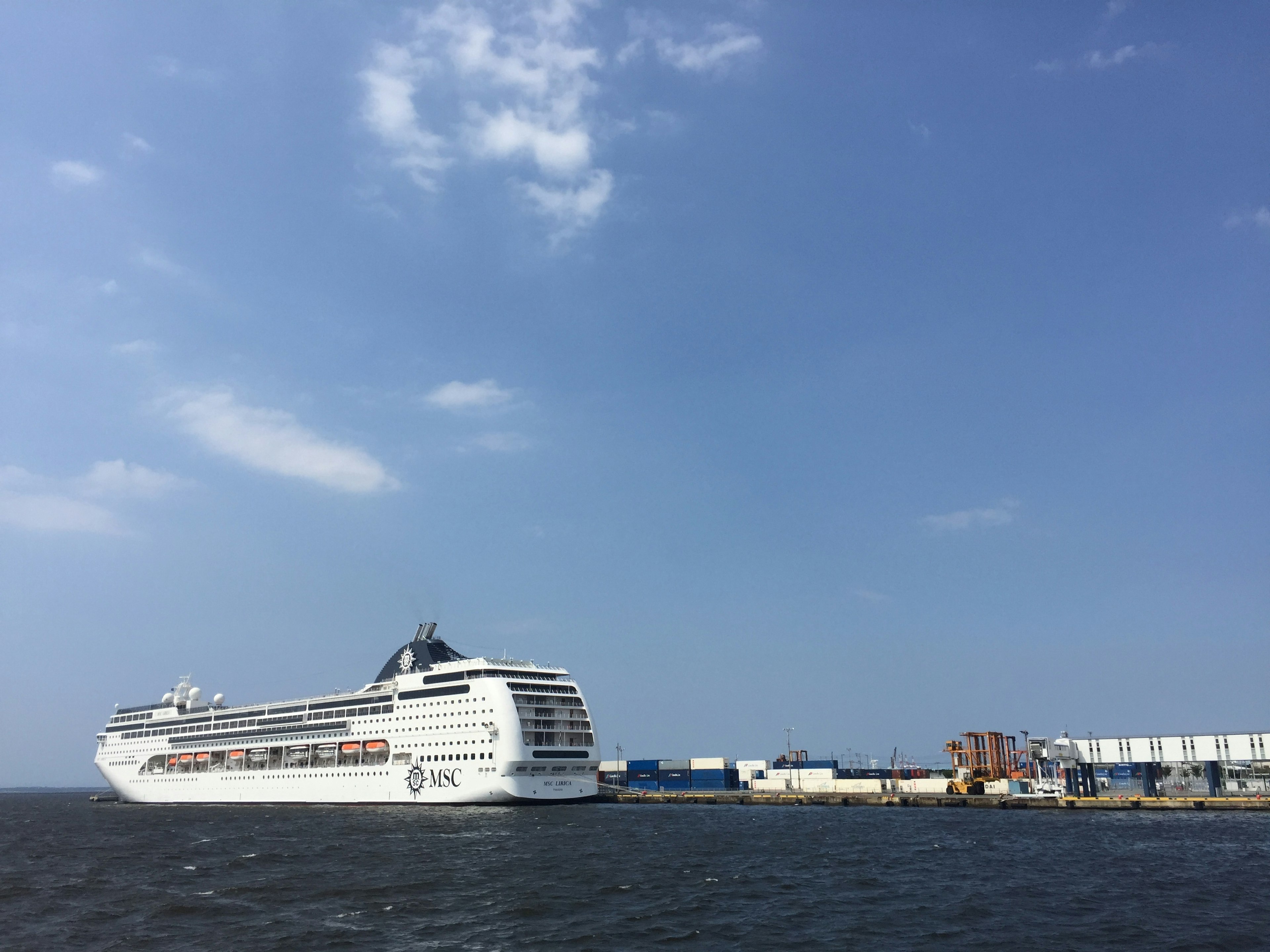 Cruise ship docked at port under a blue sky