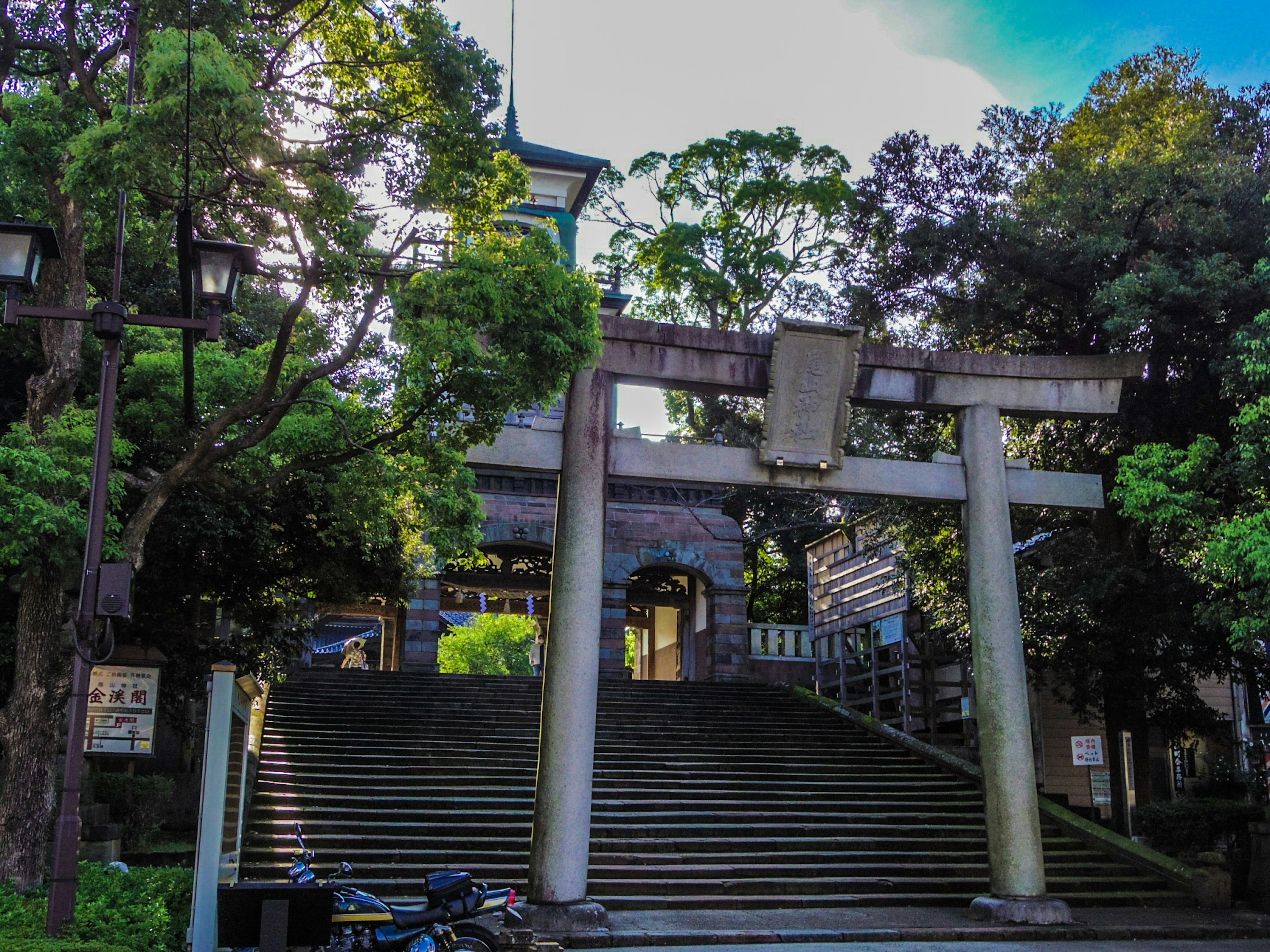 Gerbang torii dikelilingi oleh pepohonan dengan tangga