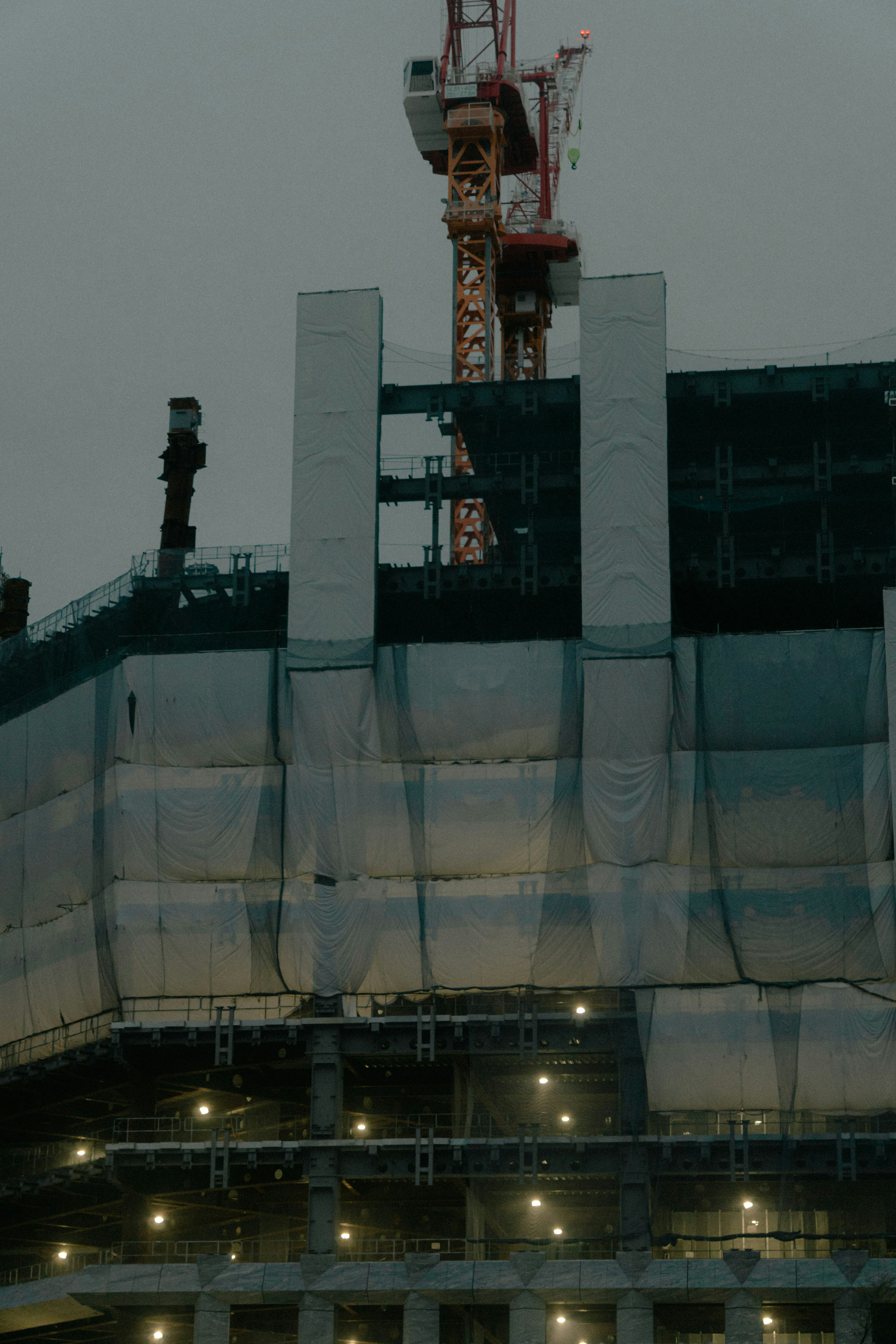 Vista de la parte superior de un edificio de gran altura en construcción con una grúa al anochecer