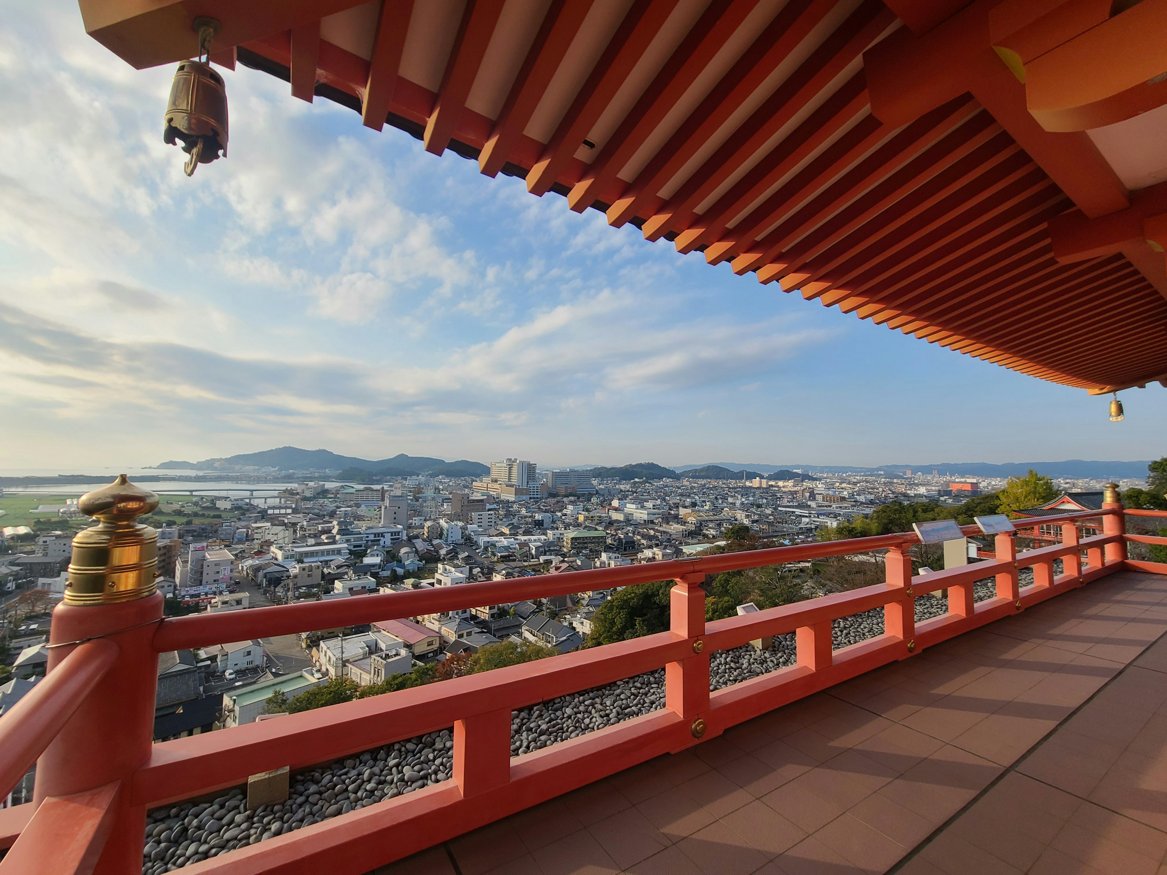 Panoramic city view with red railing and blue sky