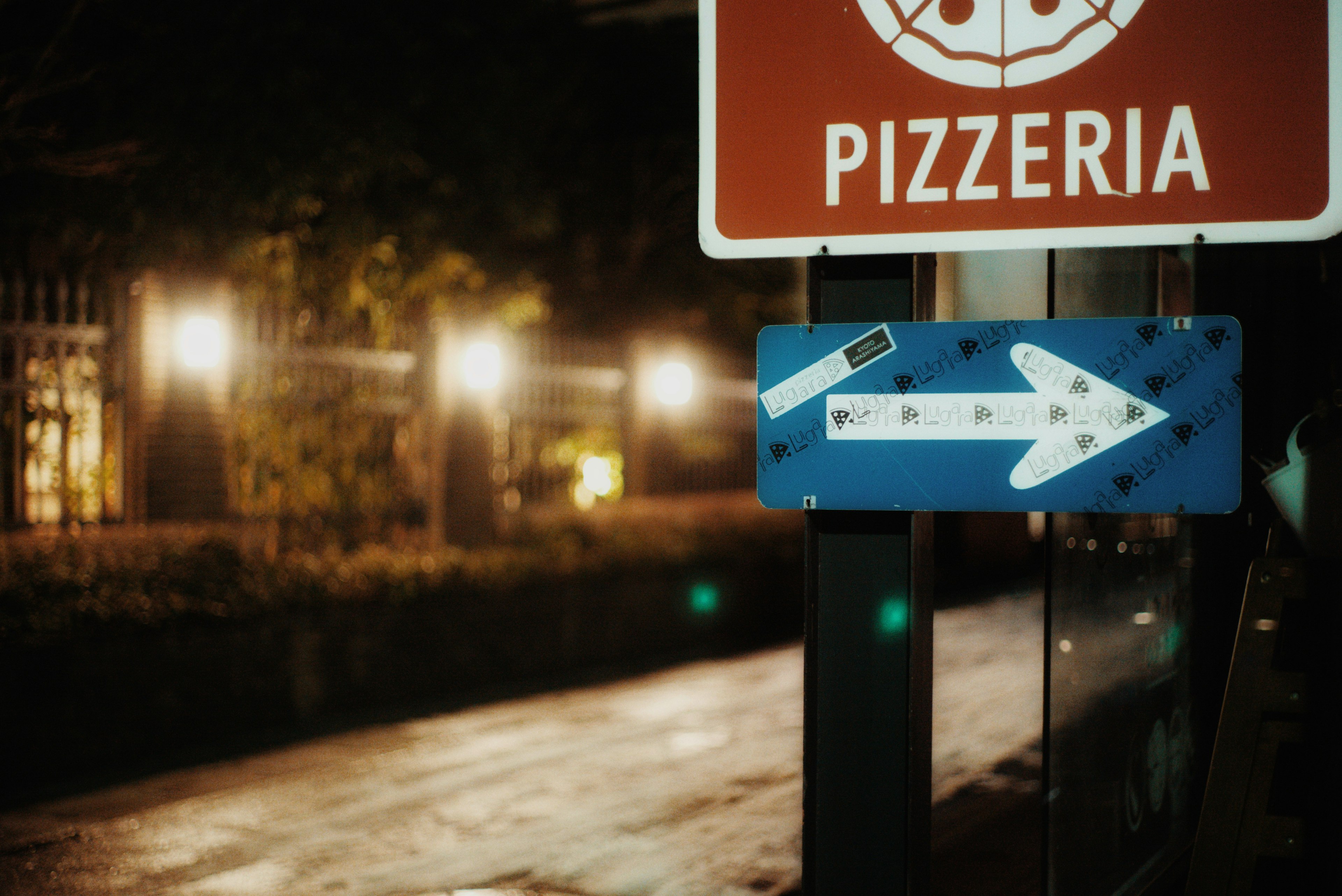 Pizzeria sign with an arrow at night