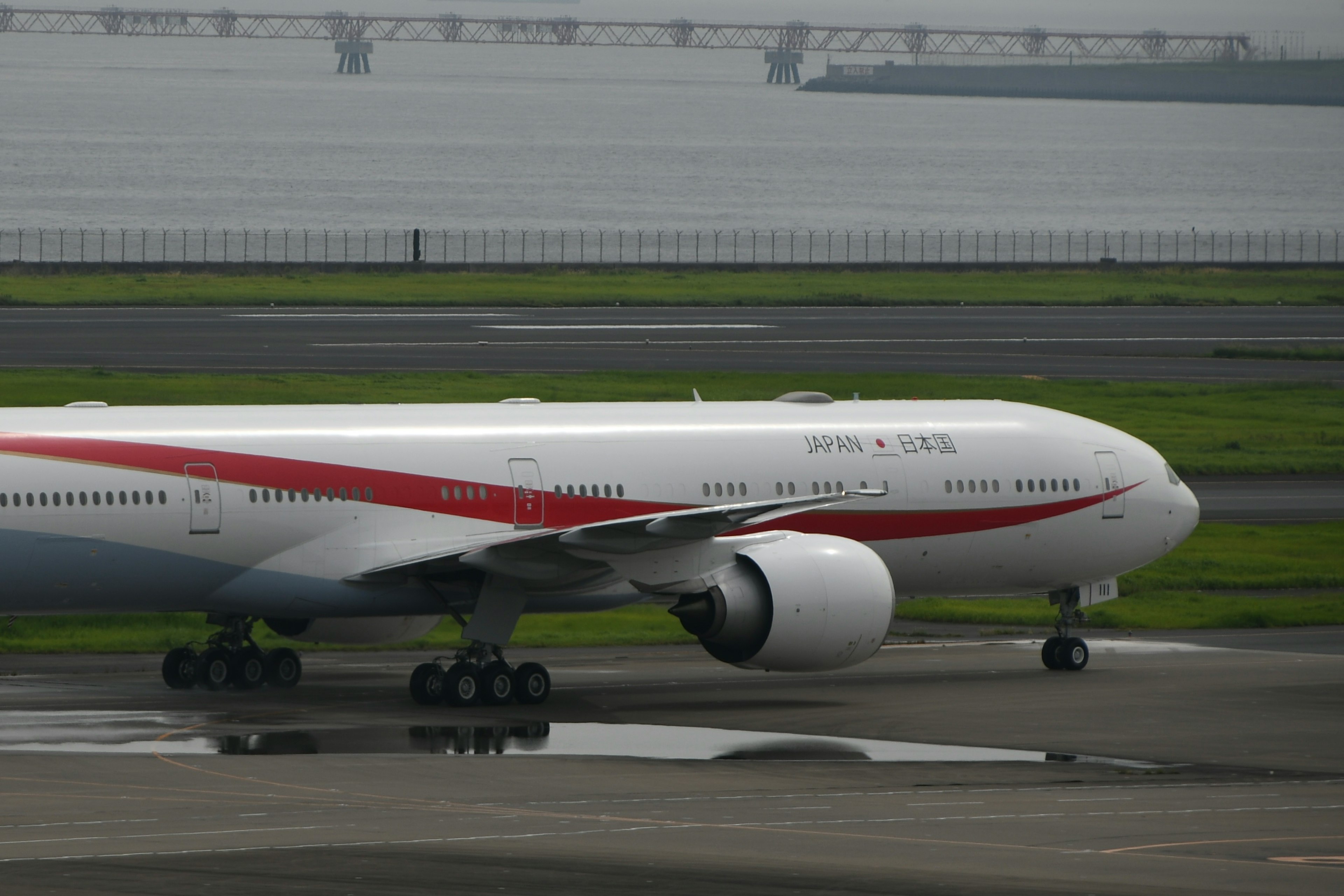 Passenger aircraft with red stripe on white body on runway