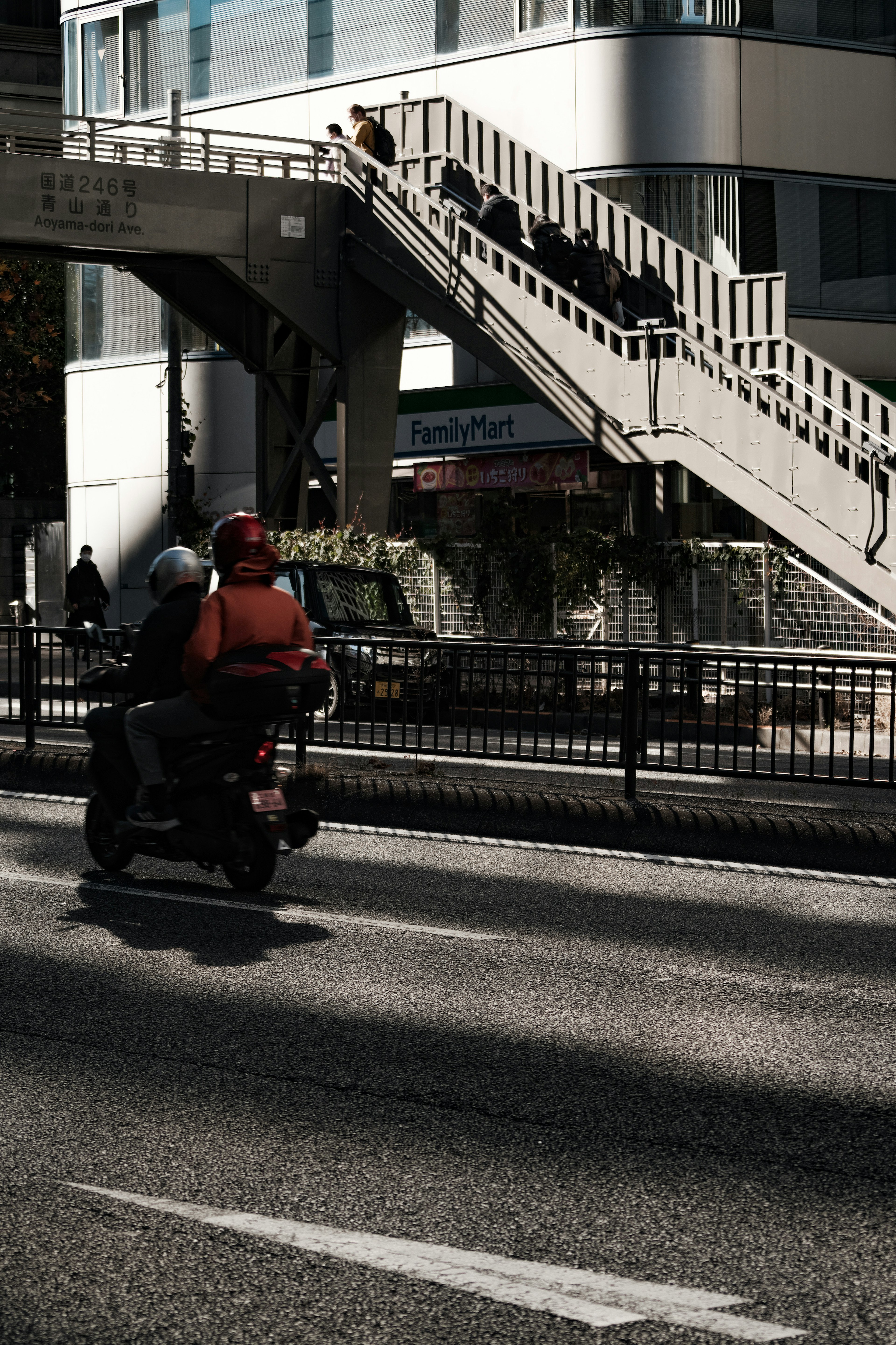 街道を走るバイクと背景の歩道橋