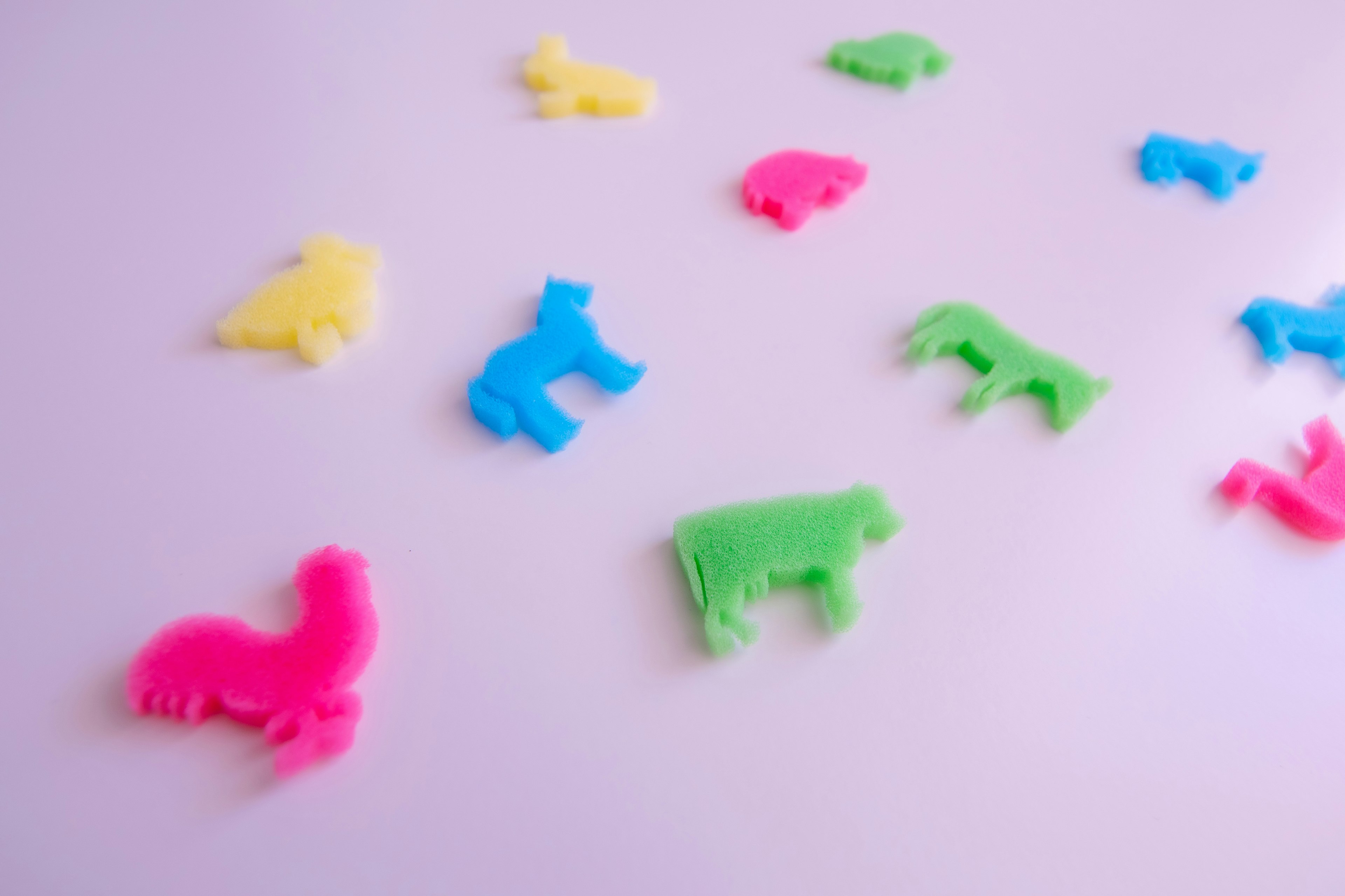 Colorful animal-shaped plastic toys scattered on a white background