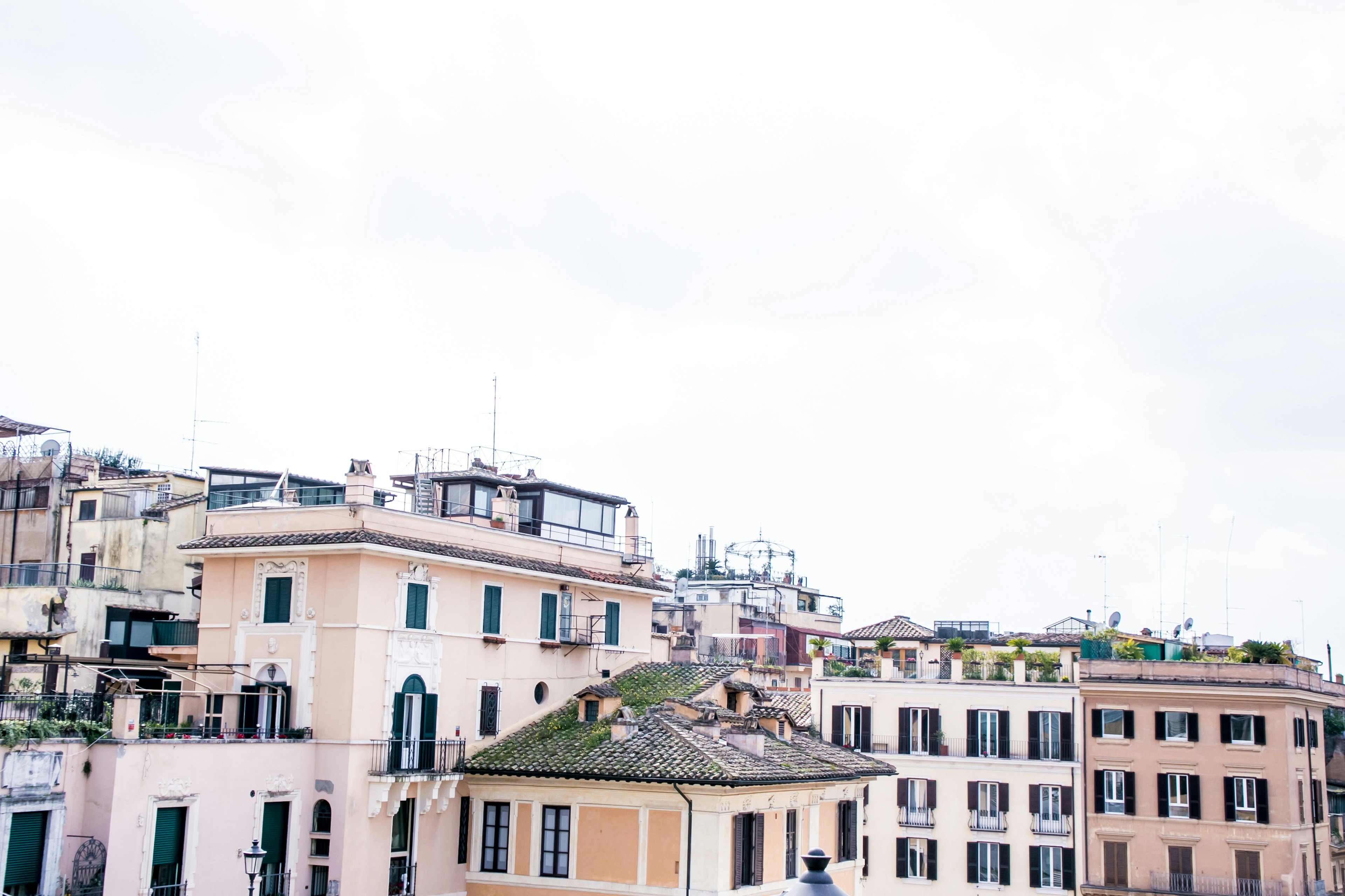 Cityscape of Rome featuring pastel-colored buildings under a cloudy sky