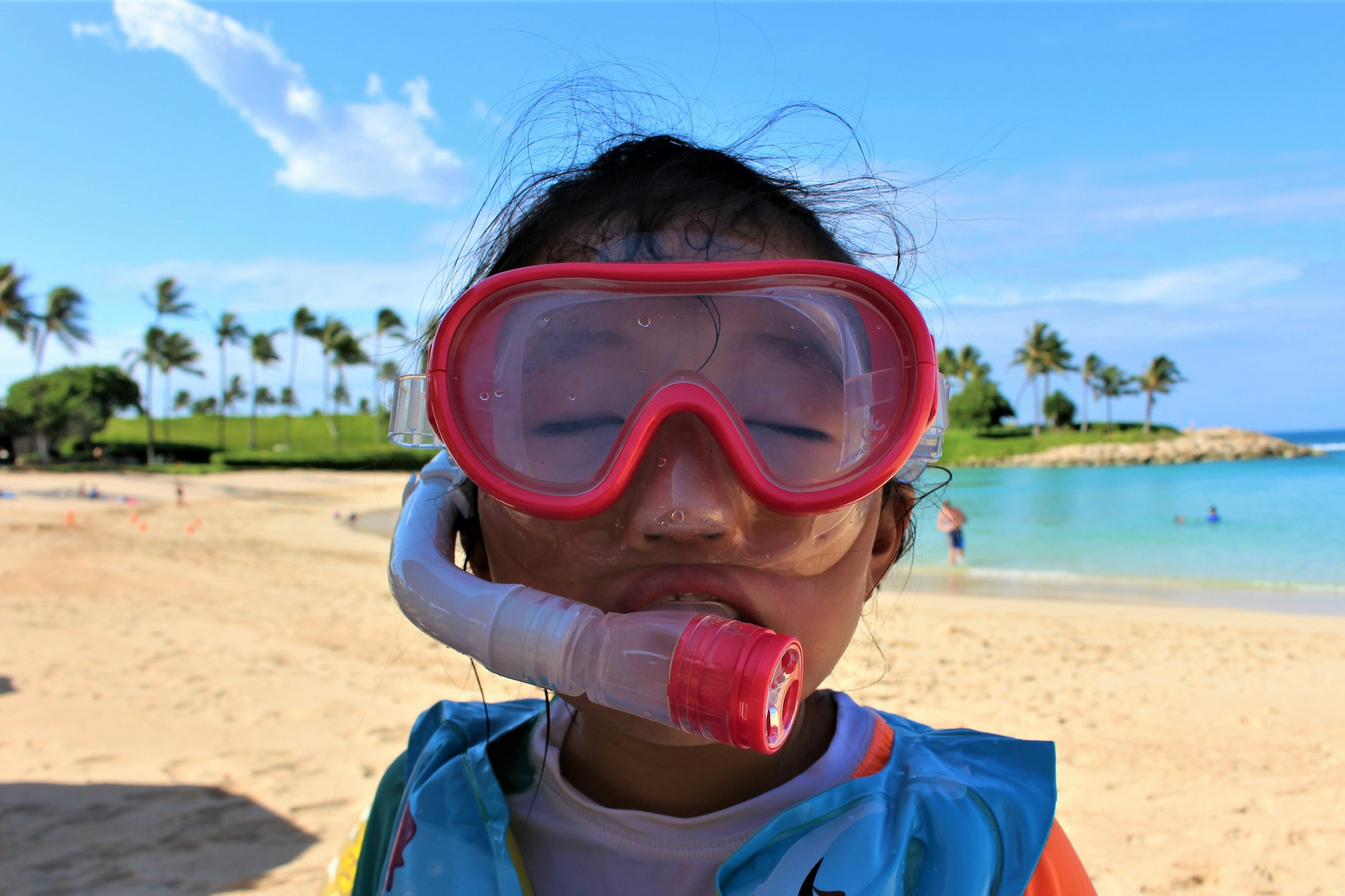 Anak tersenyum dengan peralatan snorkeling di pantai