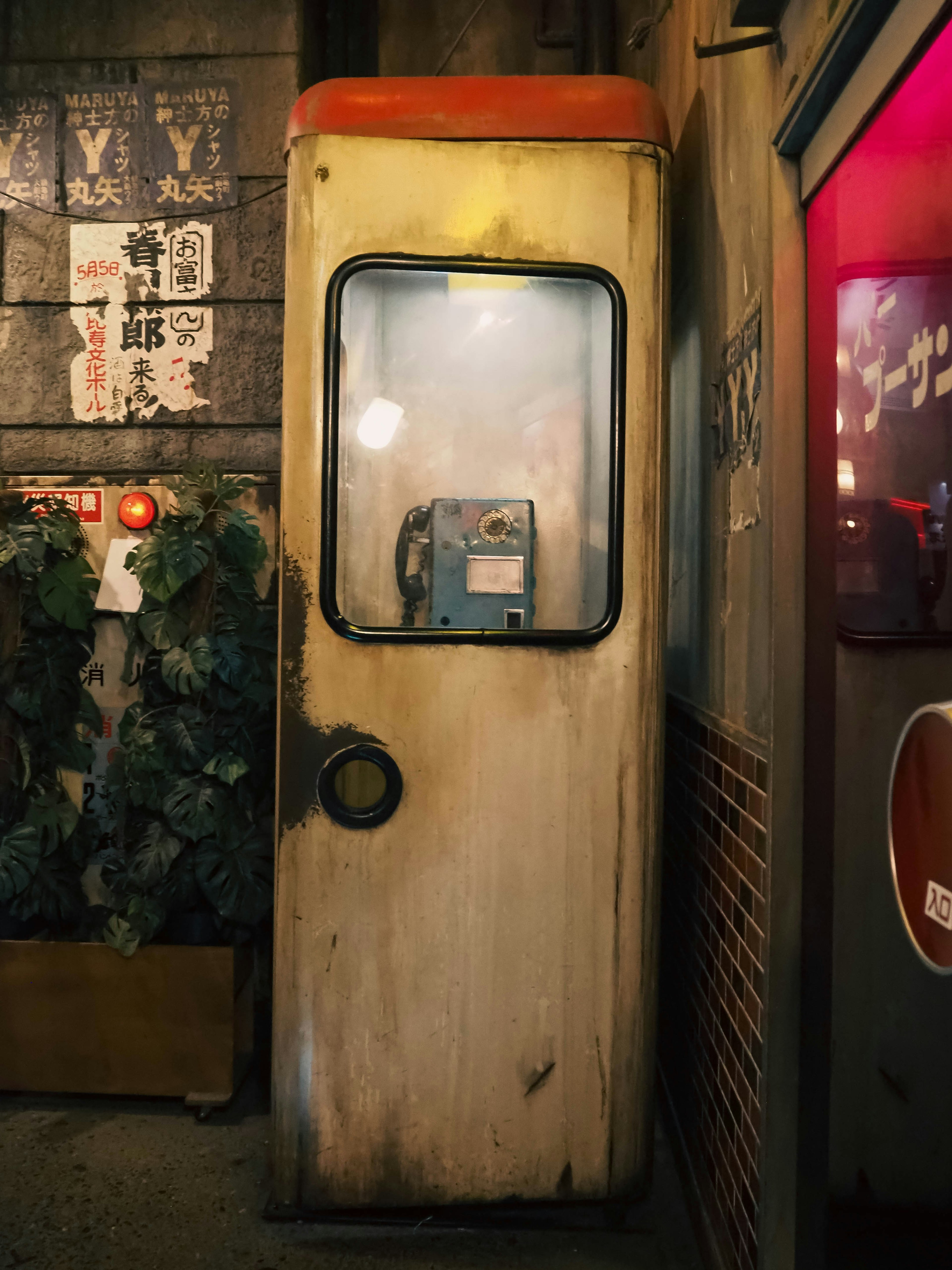 Une cabine téléphonique publique vintage adossée à un mur