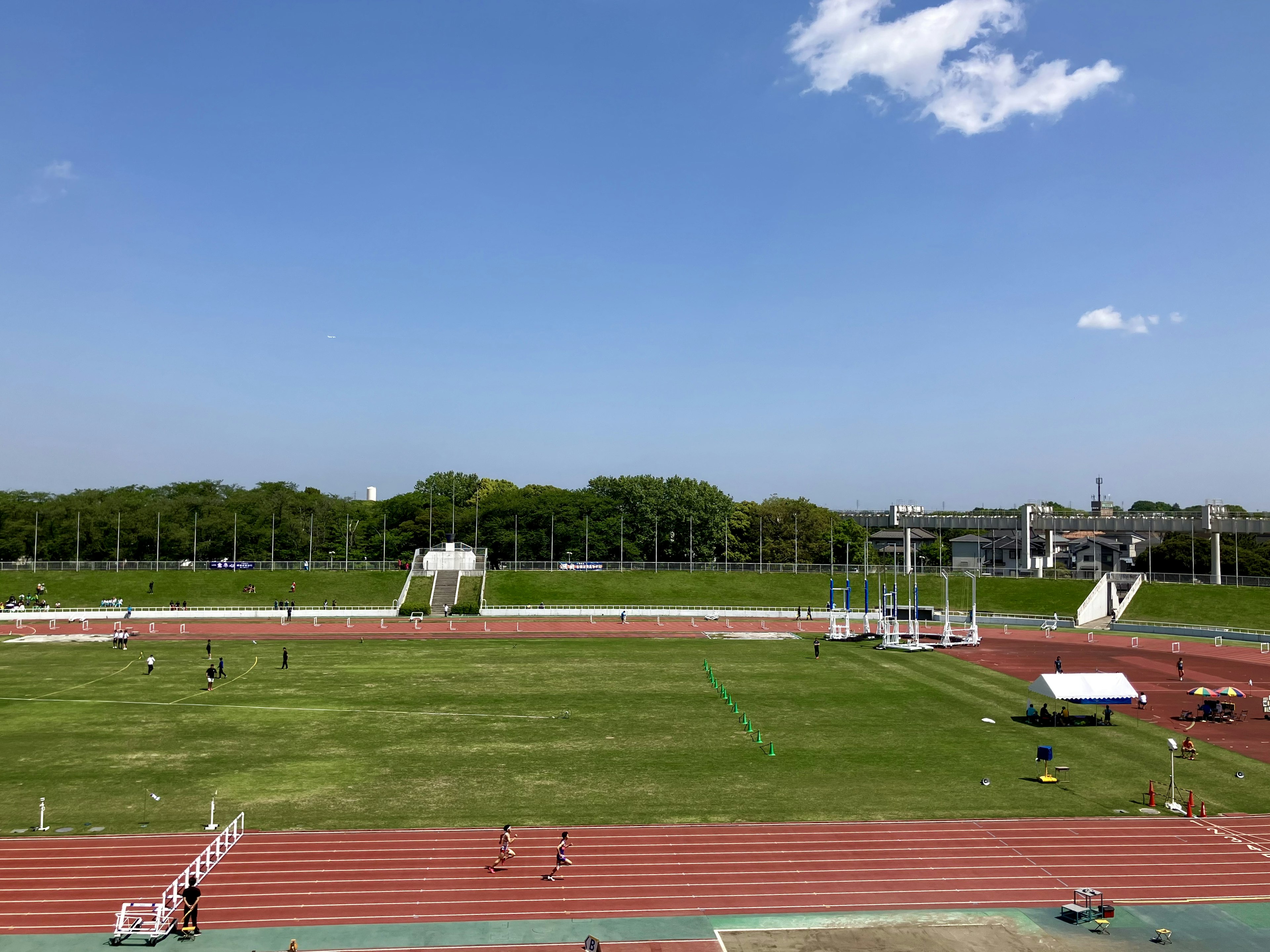 Vue d'un terrain de sport et d'une piste sous un ciel bleu clair