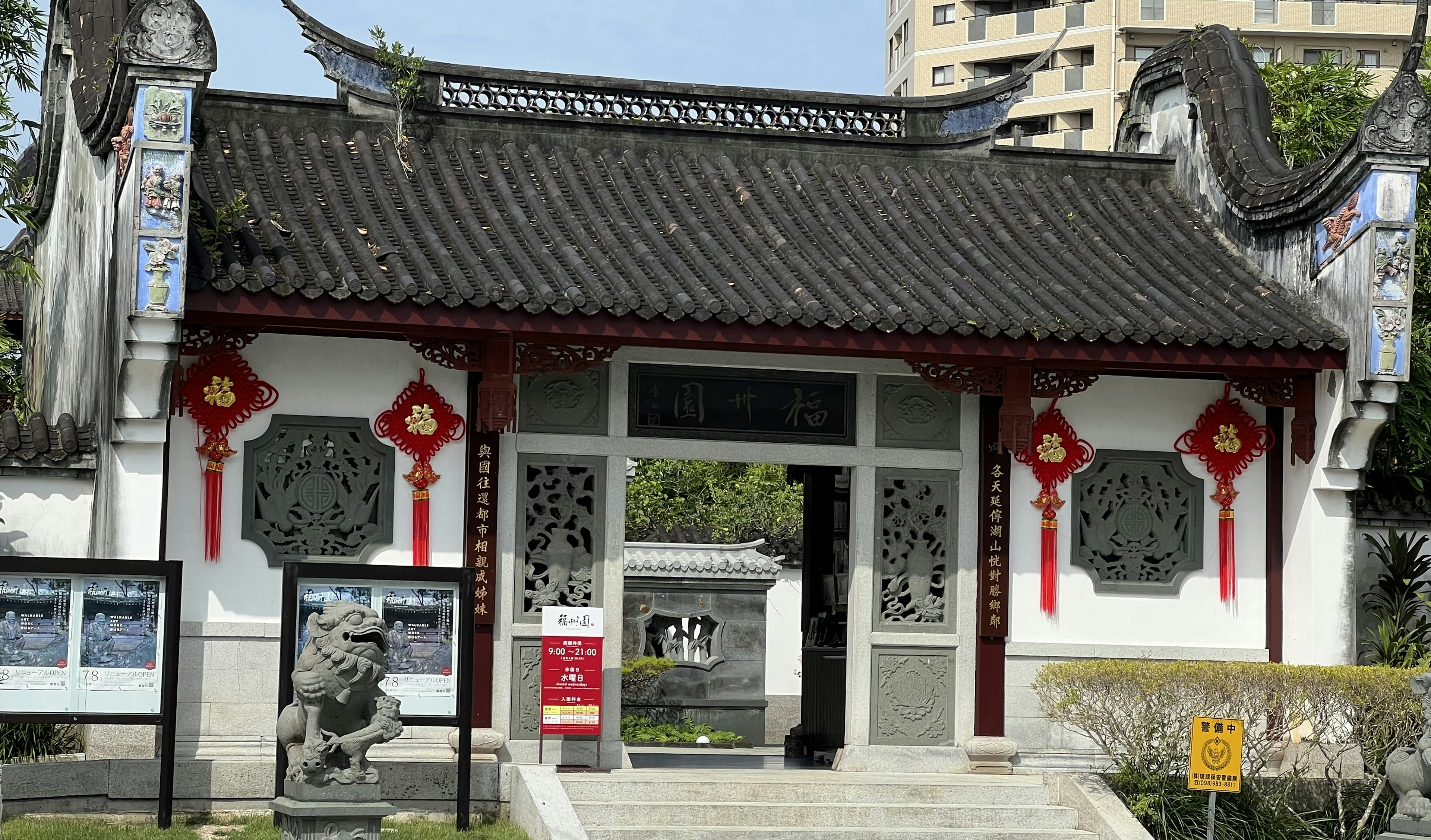 Vista exterior de una puerta arquitectónica china tradicional con decoraciones rojas y un techo curvado