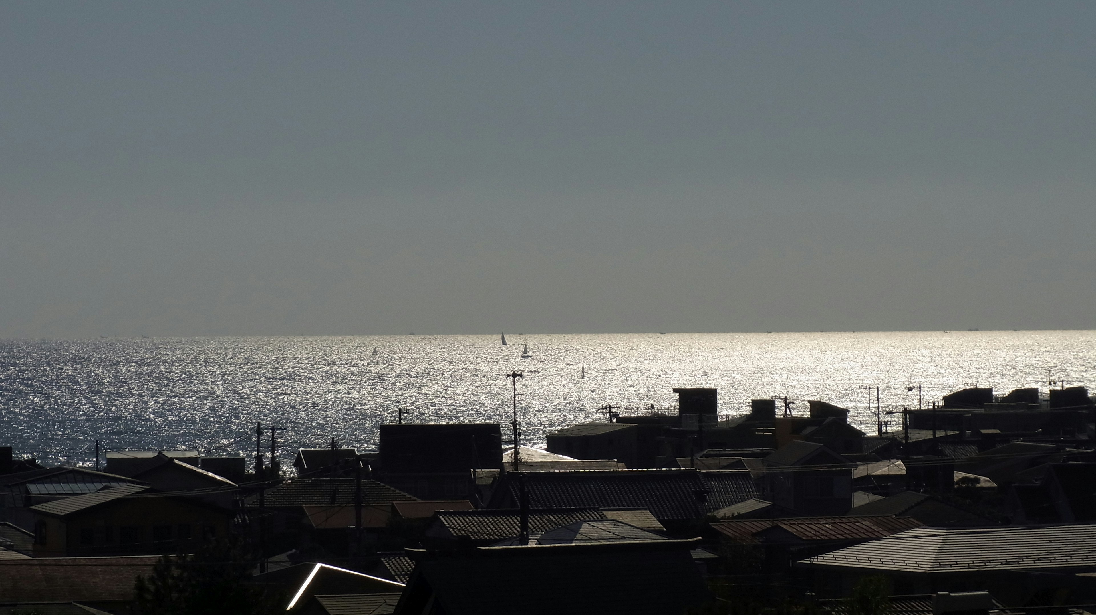 海の輝きと屋根が見える風景