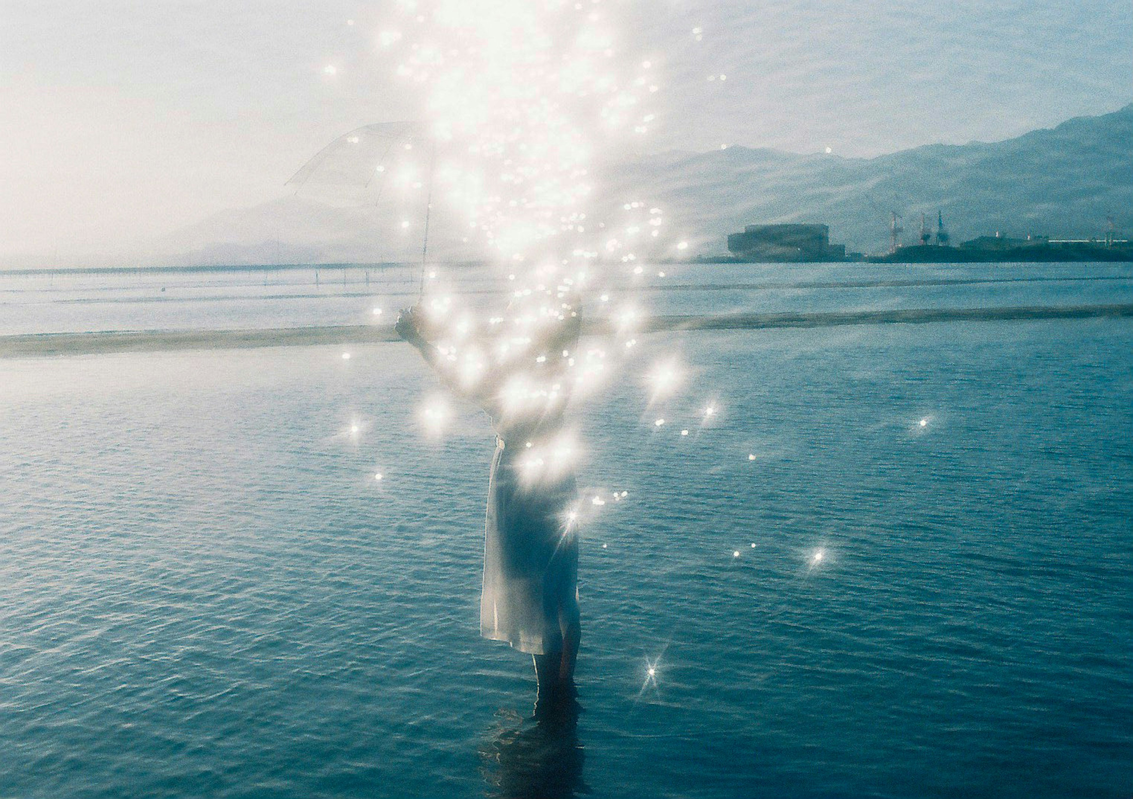 Femme en robe blanche avec des effets scintillants dans l'eau