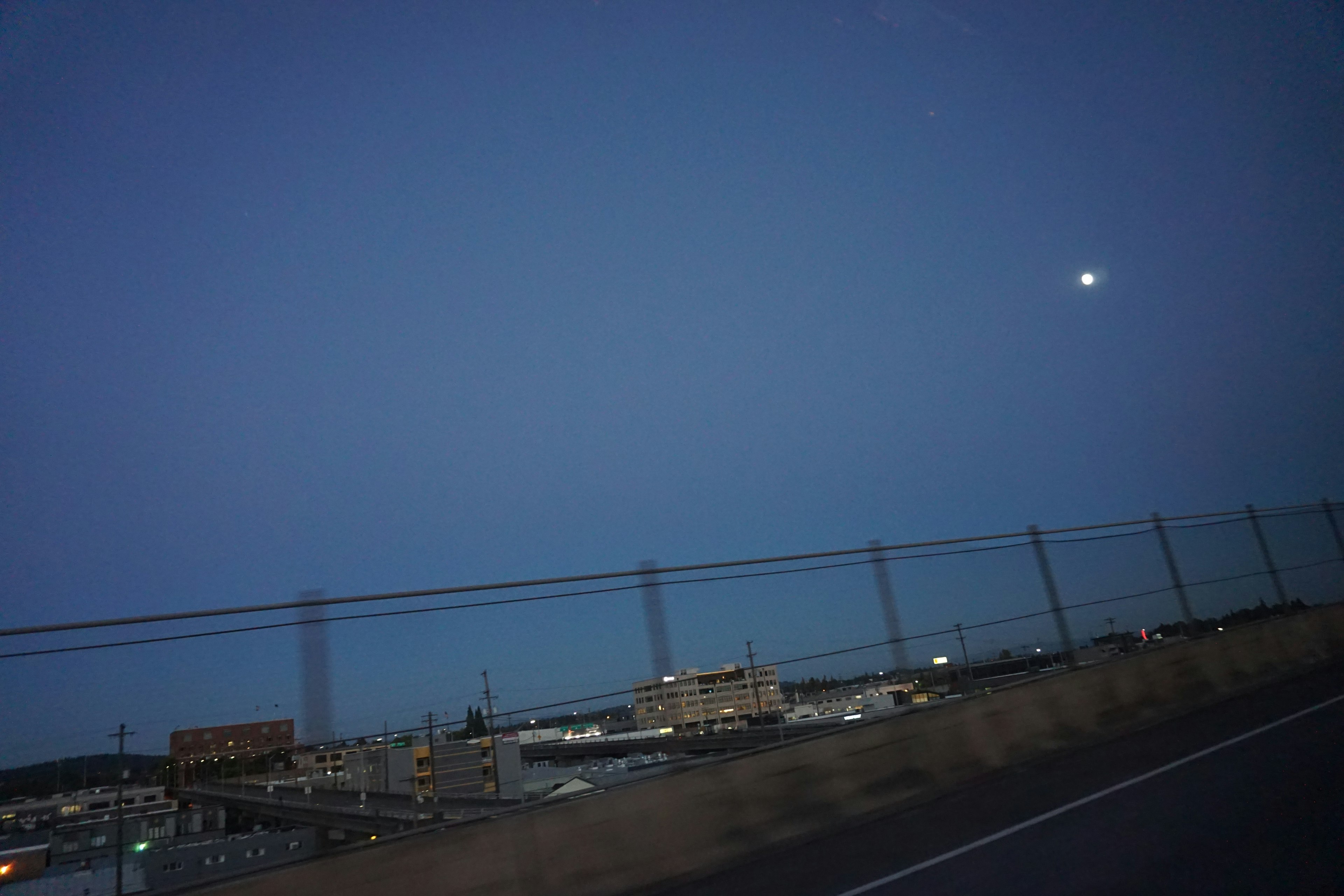 夜空に浮かぶ月と街の灯りが見える風景