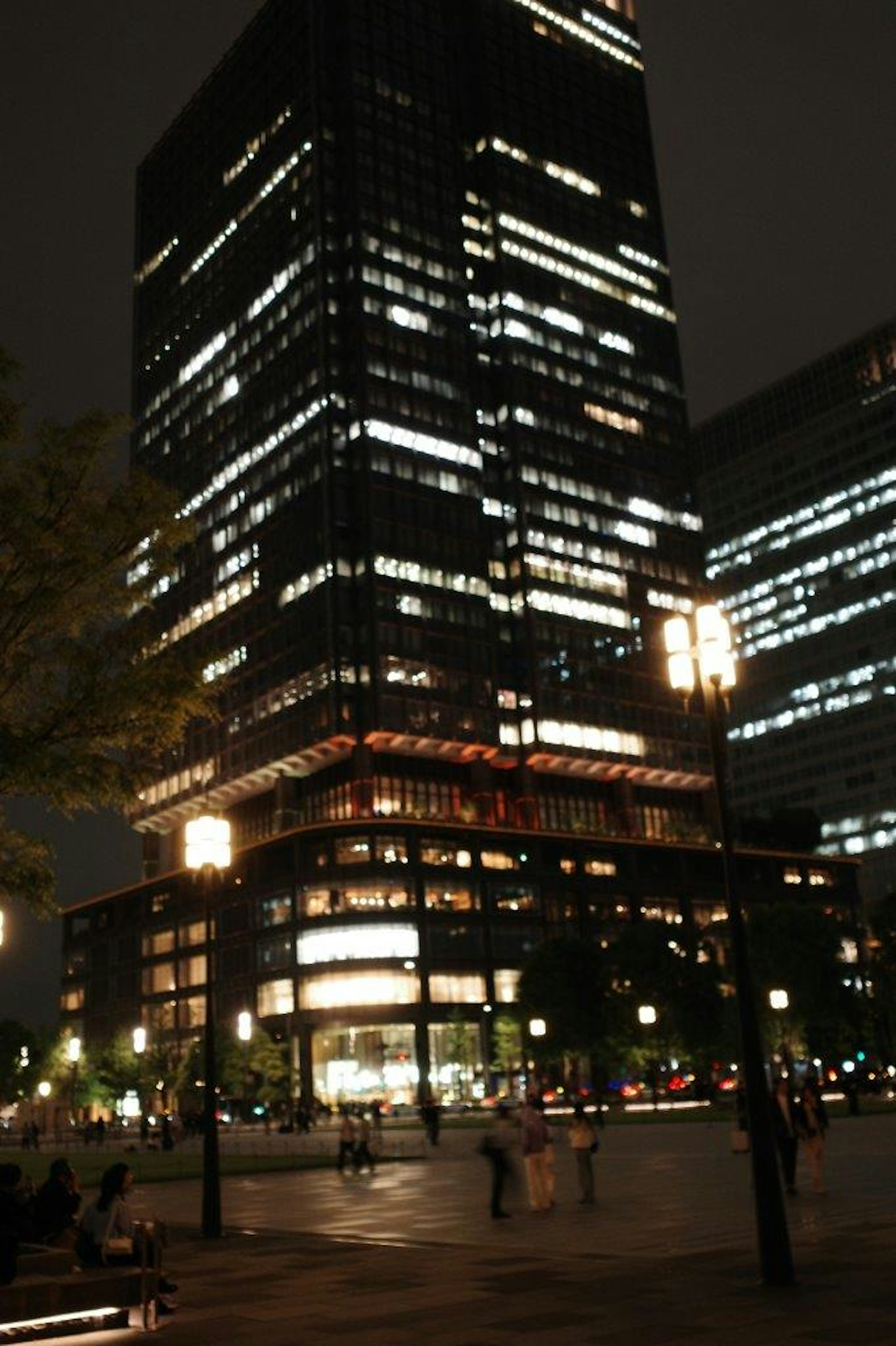 夜景の中に立つ高層ビルと周囲の街灯