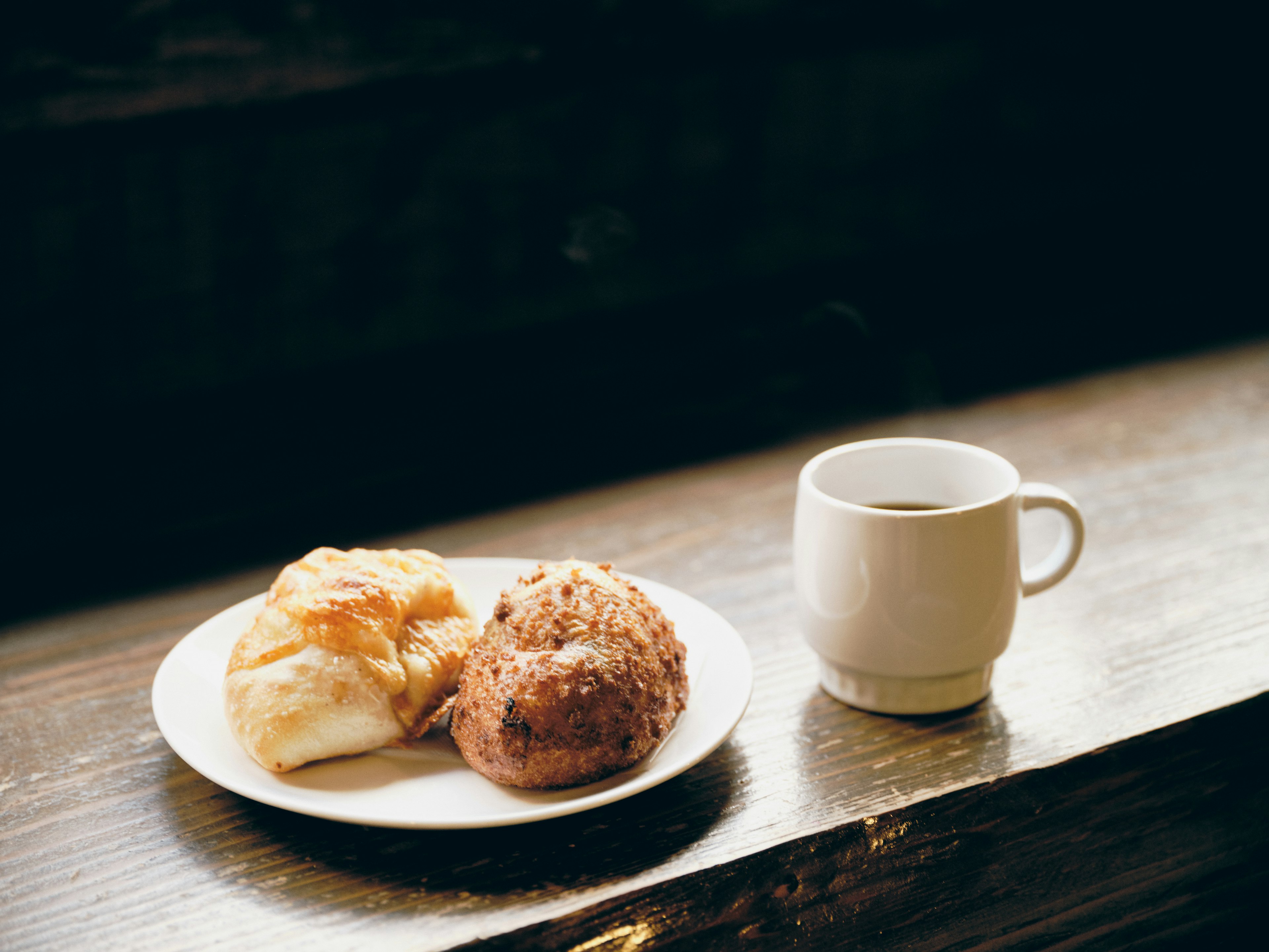 Pemandangan nyaman dengan kue dan secangkir kopi di atas meja kayu