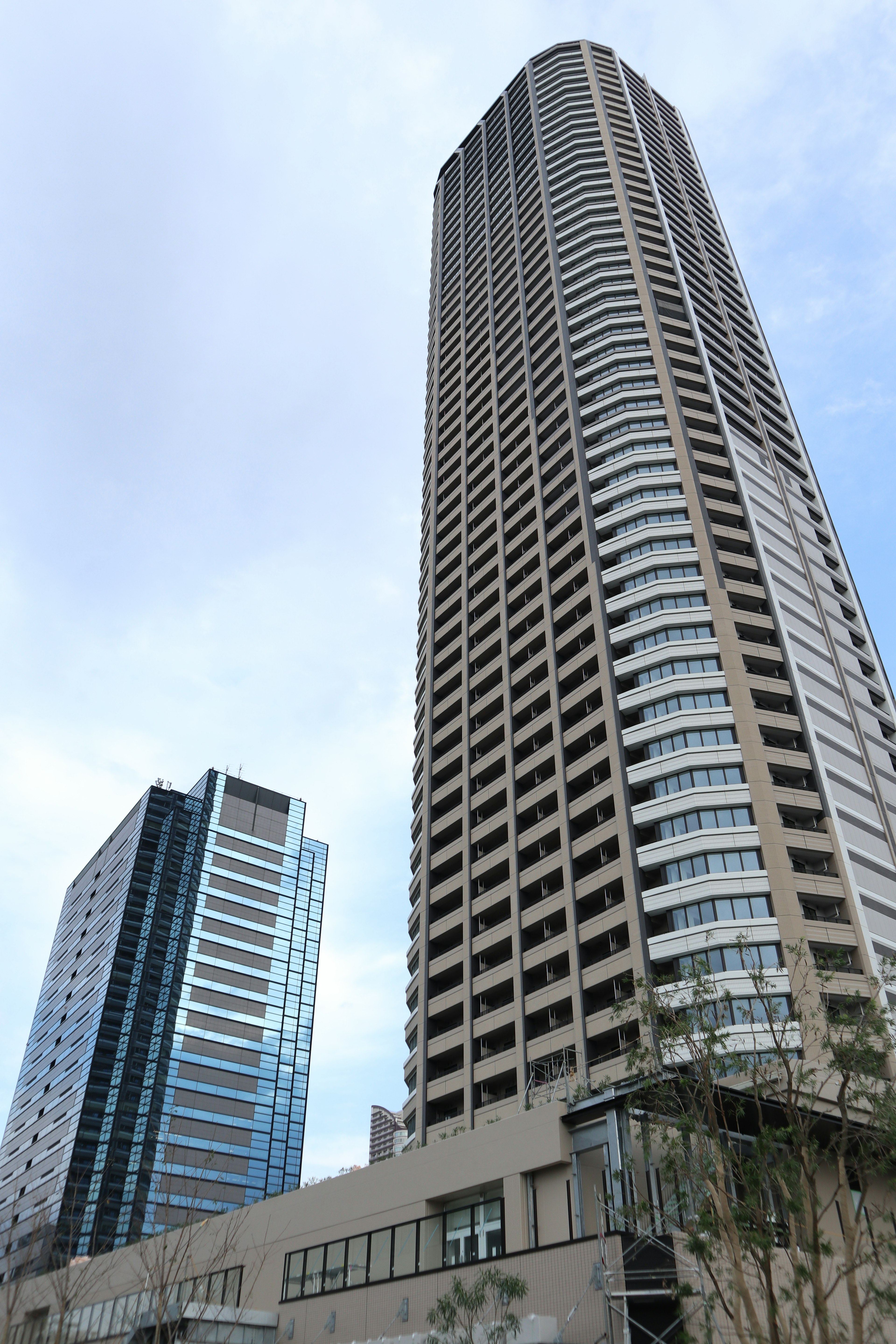 Photo of skyscrapers with a focus on a tall building and a nearby glass structure