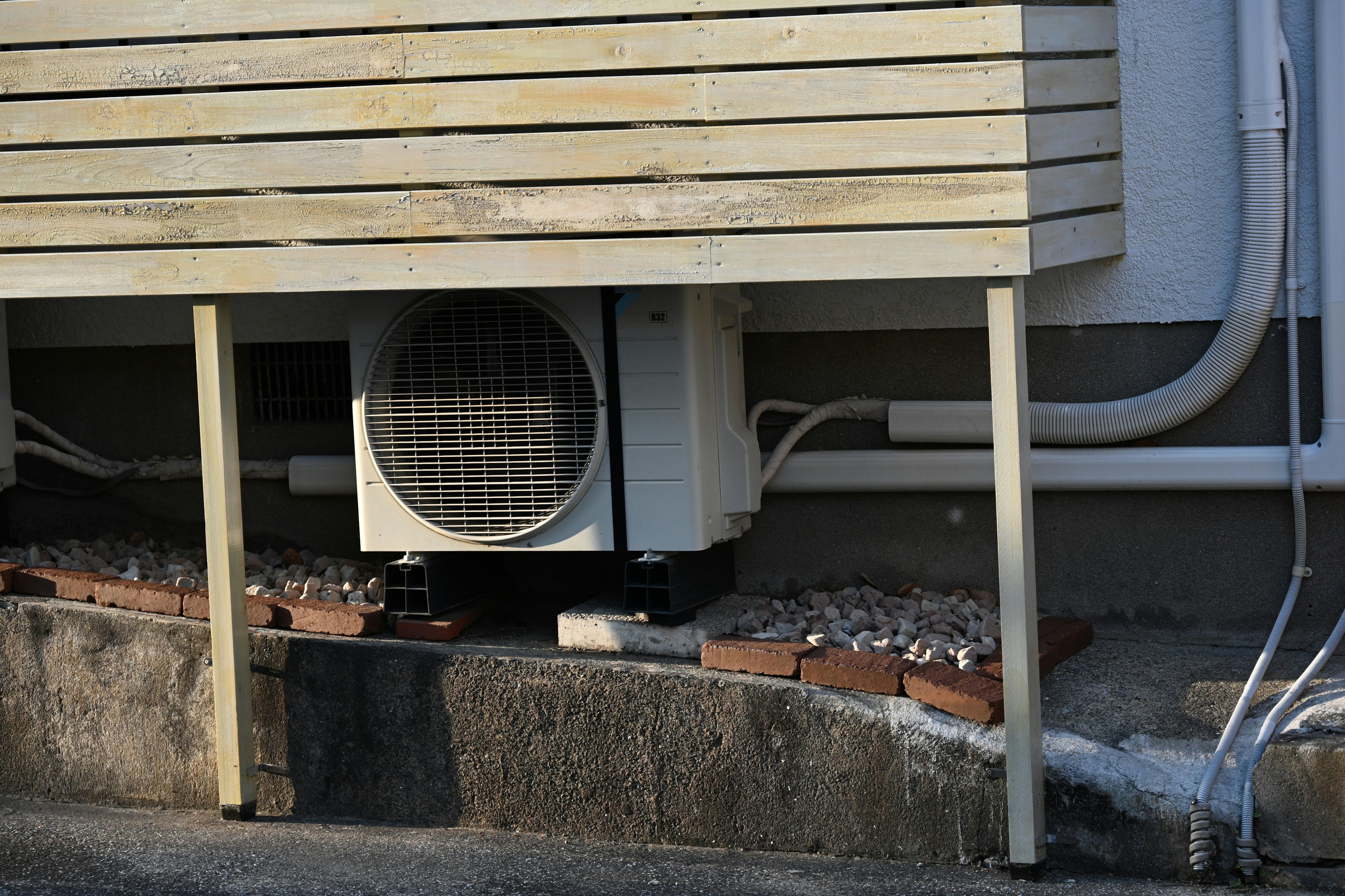 Air conditioning unit installed under wooden panel with visible piping