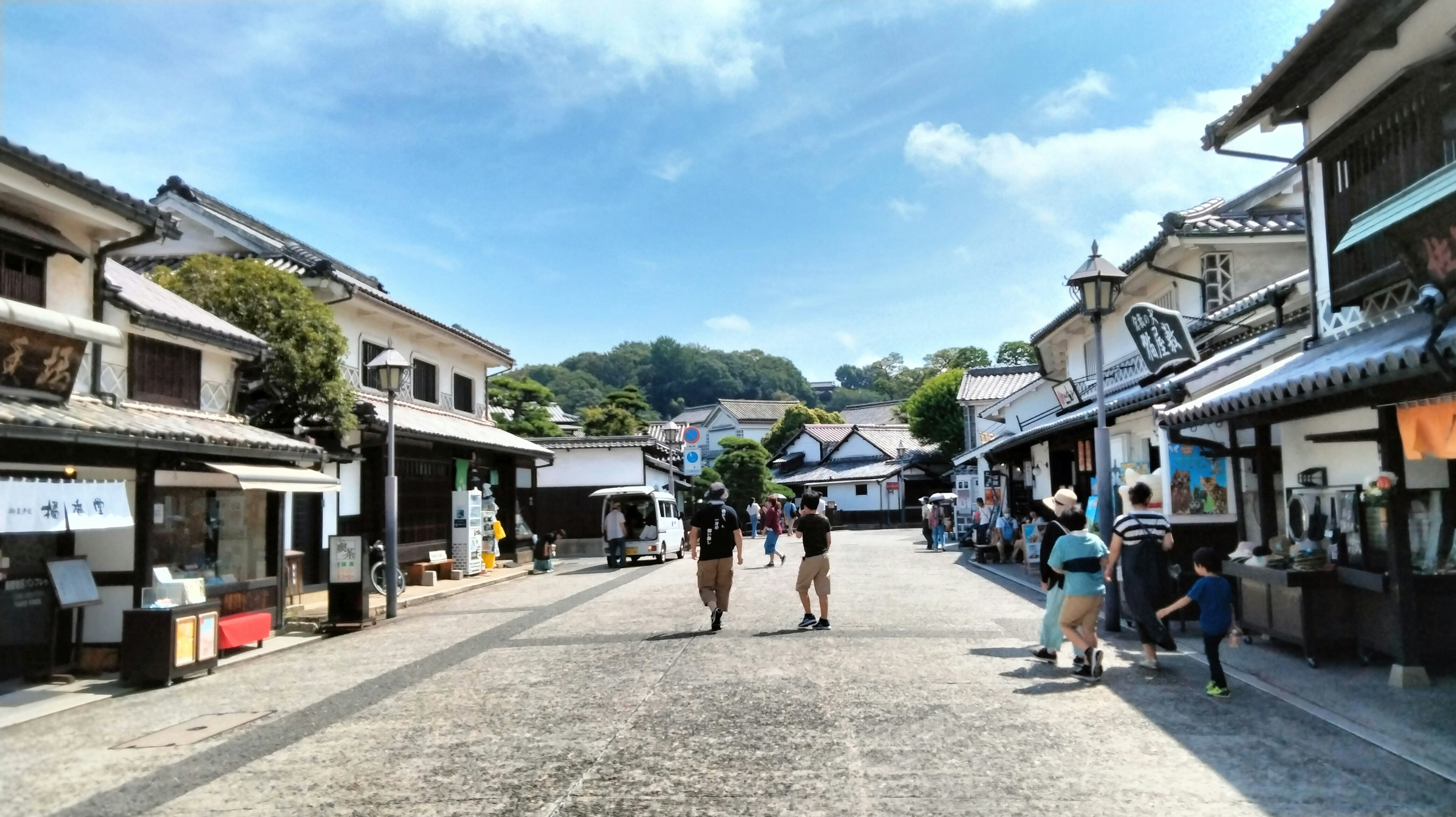 Historic street with people walking and blue sky