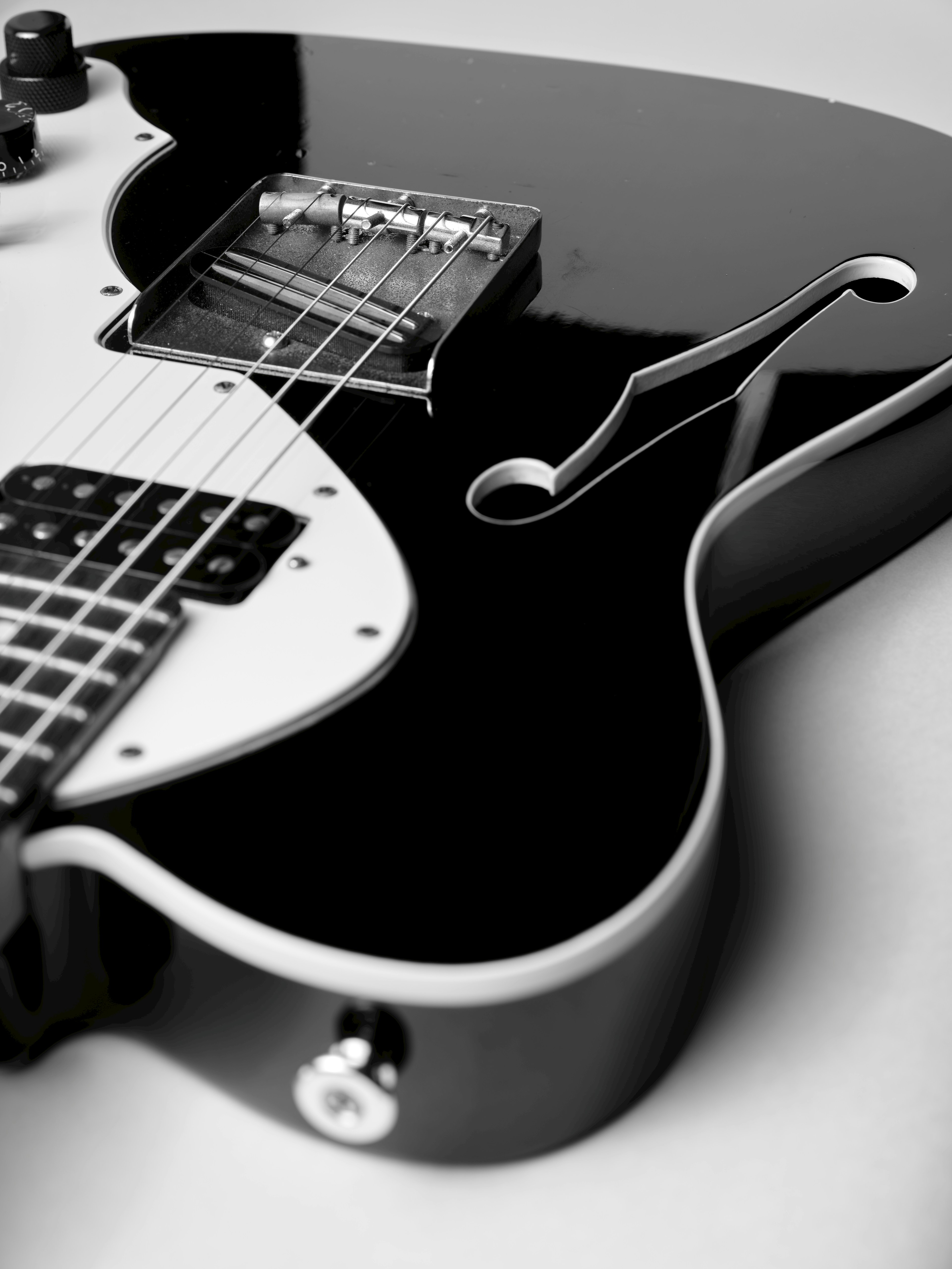 Close-up of a black and white electric guitar body