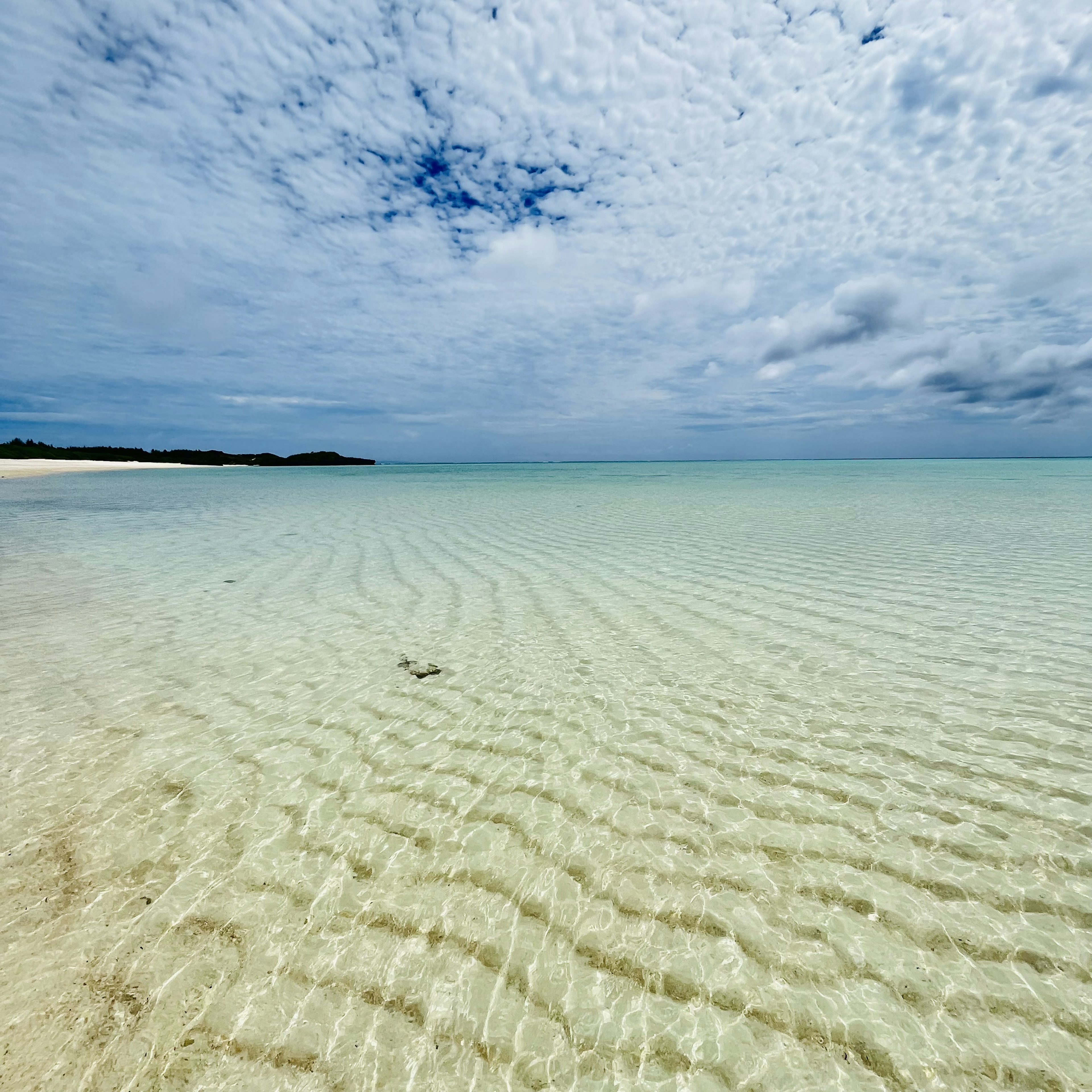 Szenische Aussicht auf ein ruhiges Meer mit welligem klarem Wasser unter einem blauen Himmel