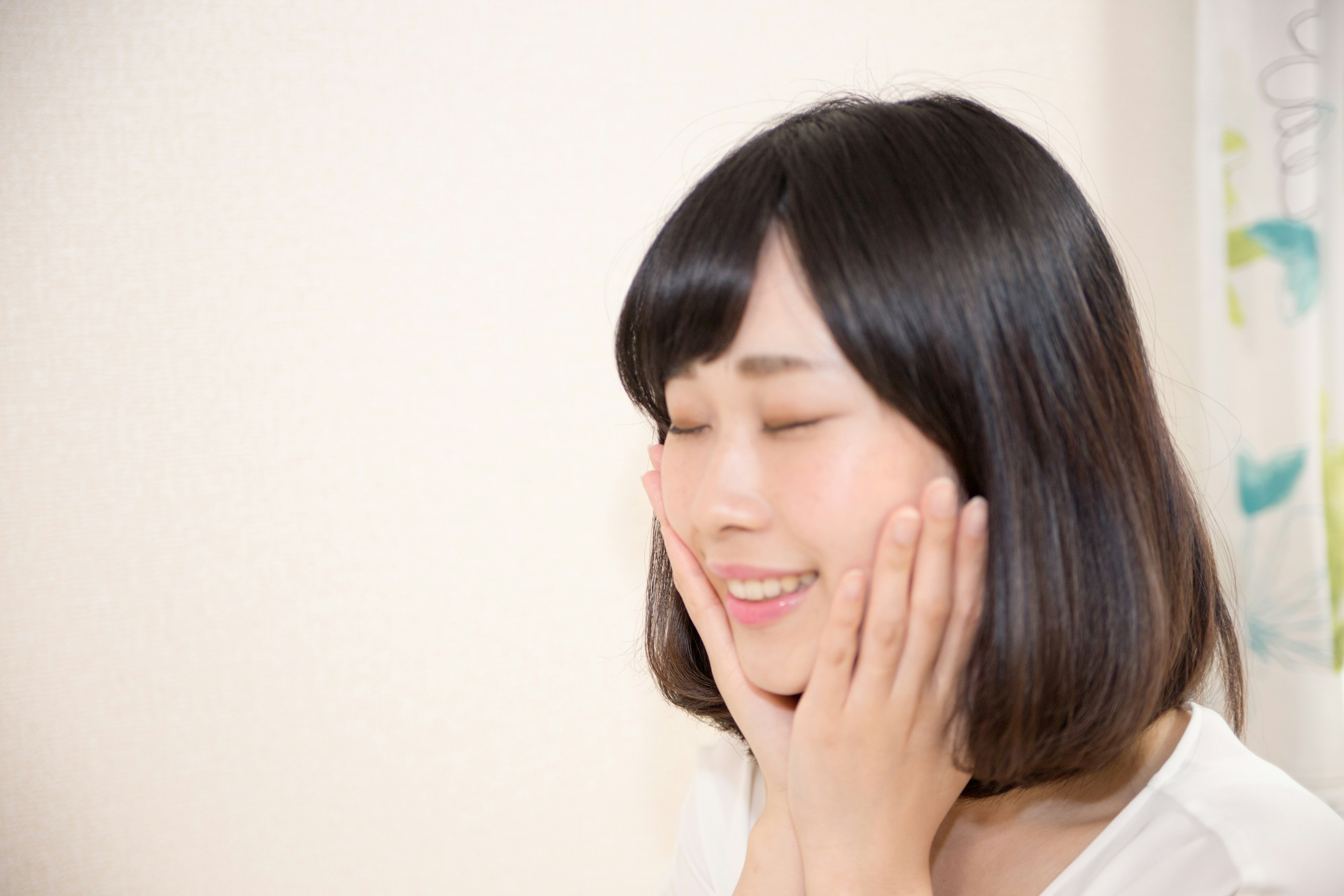 A woman smiling with her hands on her cheeks