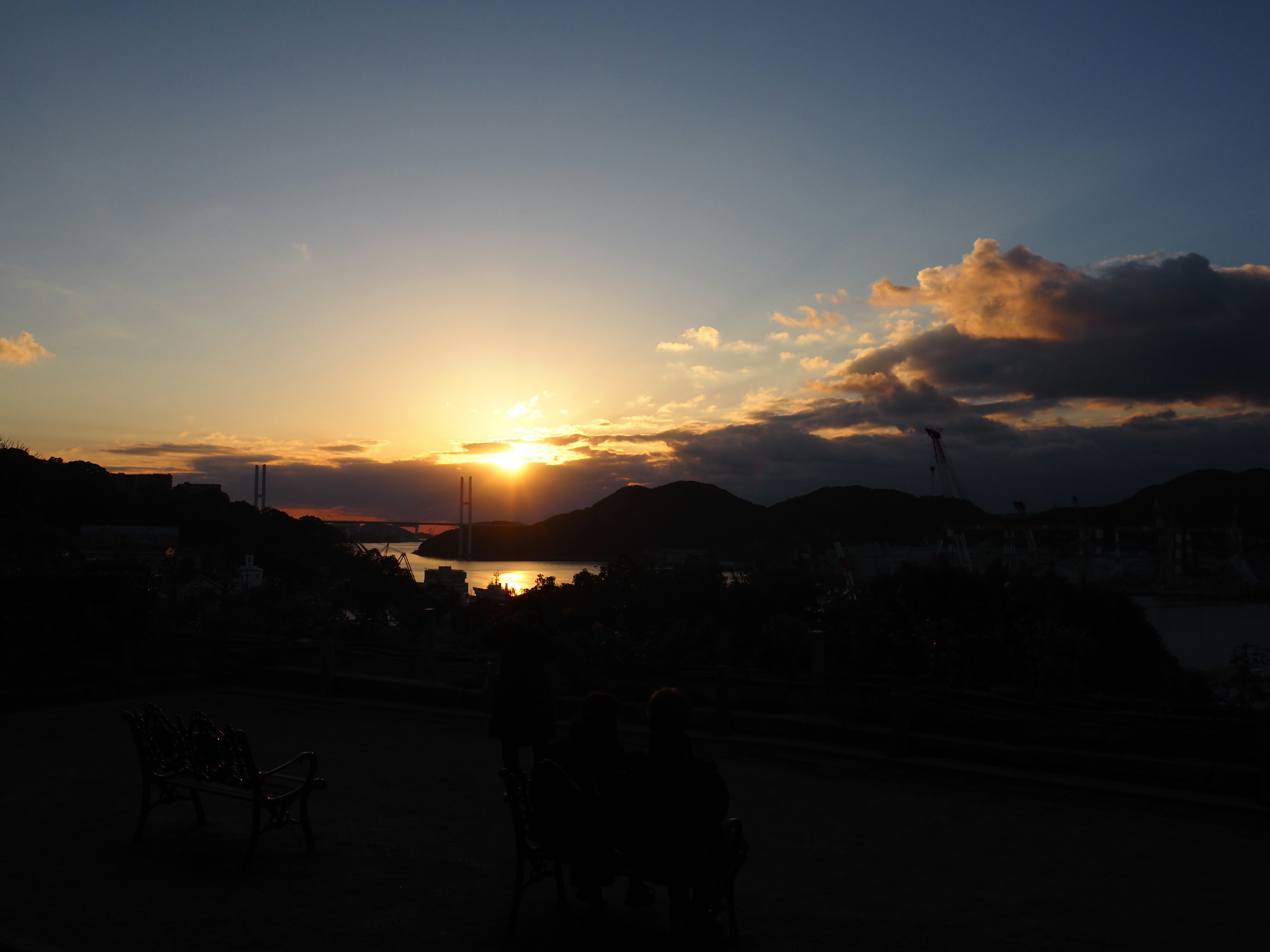 Vue panoramique d'un coucher de soleil sur une côte avec des montagnes et des nuages