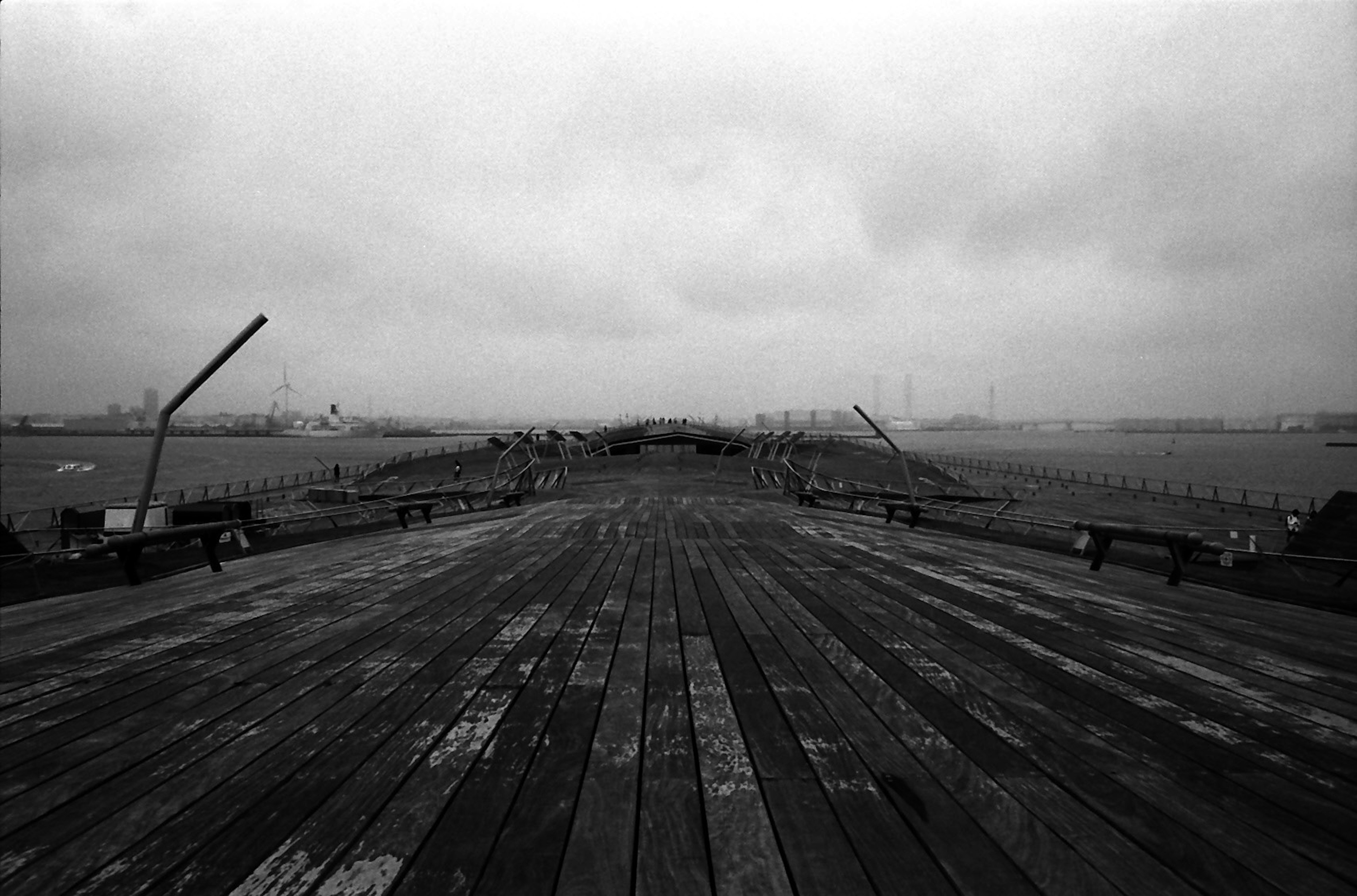 A dilapidated wooden pier extending into a foggy landscape